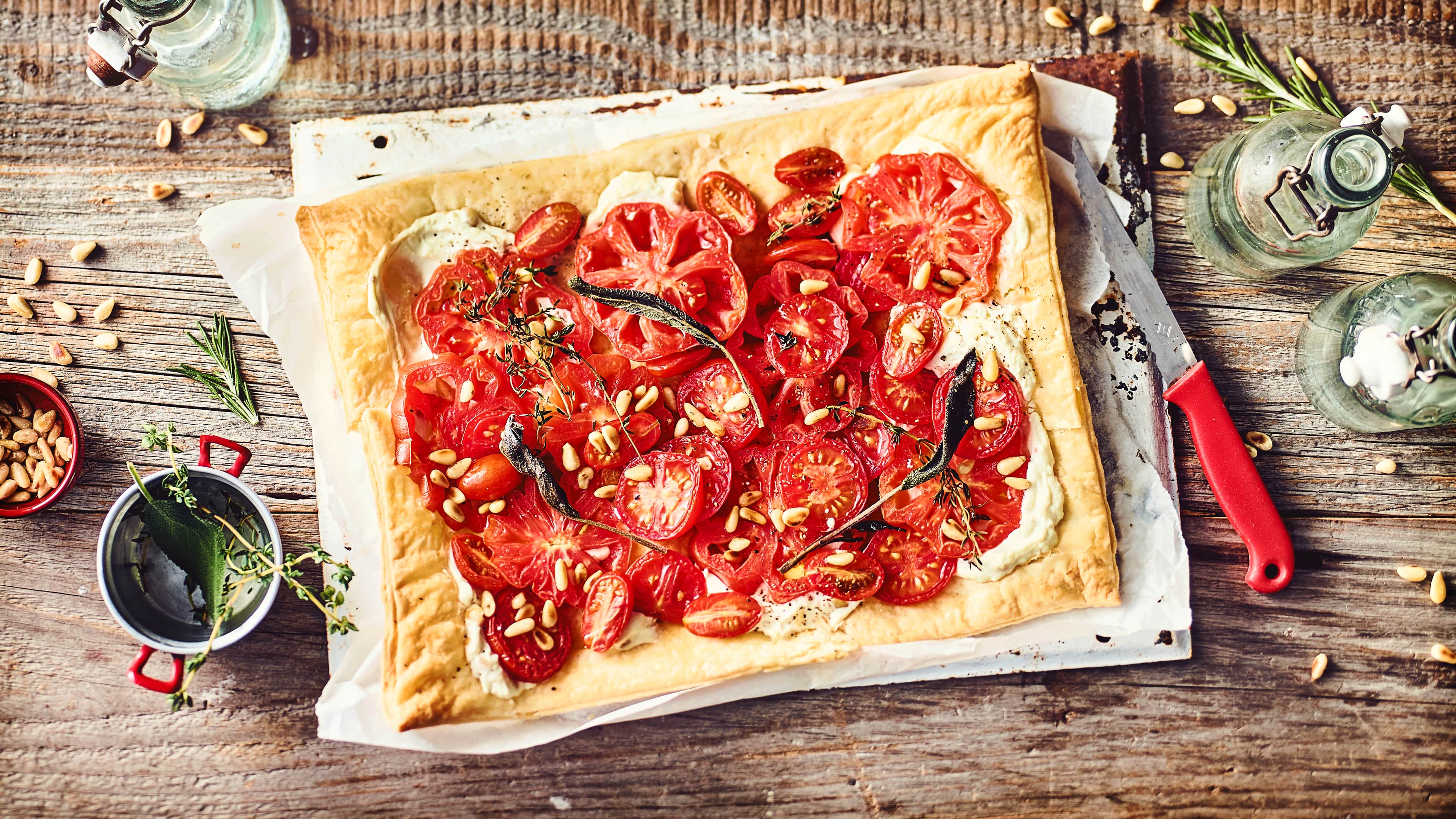 Tomaten-Pinien-Tarte Leichtes Sommergericht vom Blech: Probieren Sie unsere Tomaten-Pinien-Tarte mit Ricotta und Zitronenthymian – vegetarisch und mediterran!