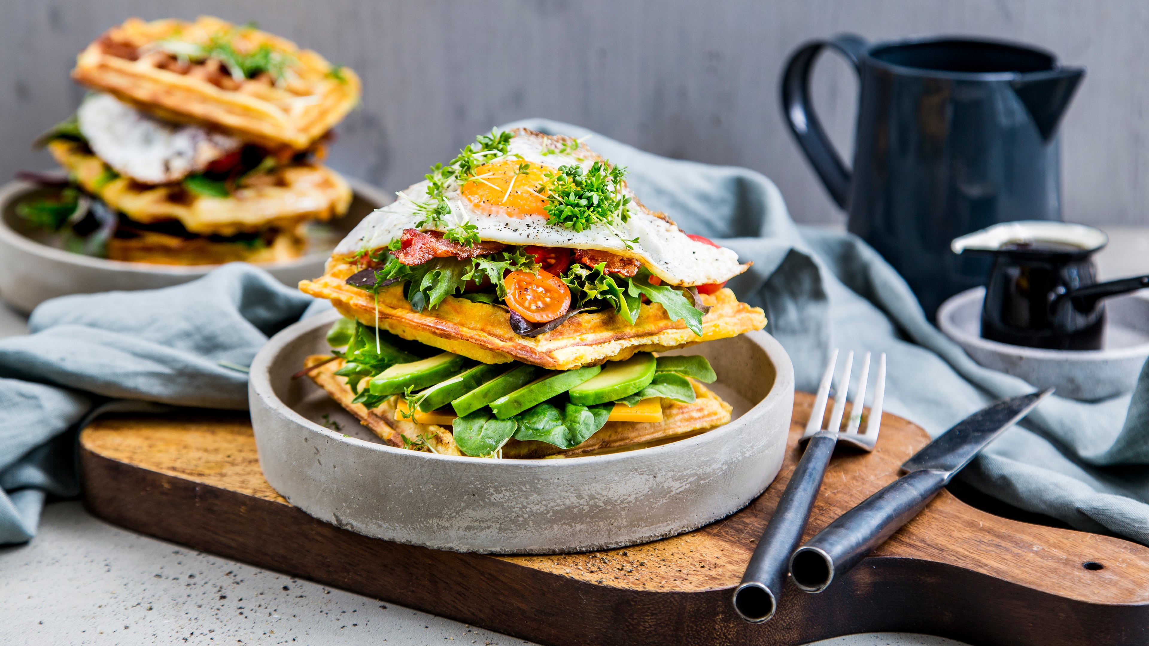Kennen Sie schon Waffel-BLT? Sonst wird es höchste Zeit für die herzhafte Süßkartoffel-Polenta-Waffel mit Bacon, Eiern, Avocado und würzigem Cheddar.