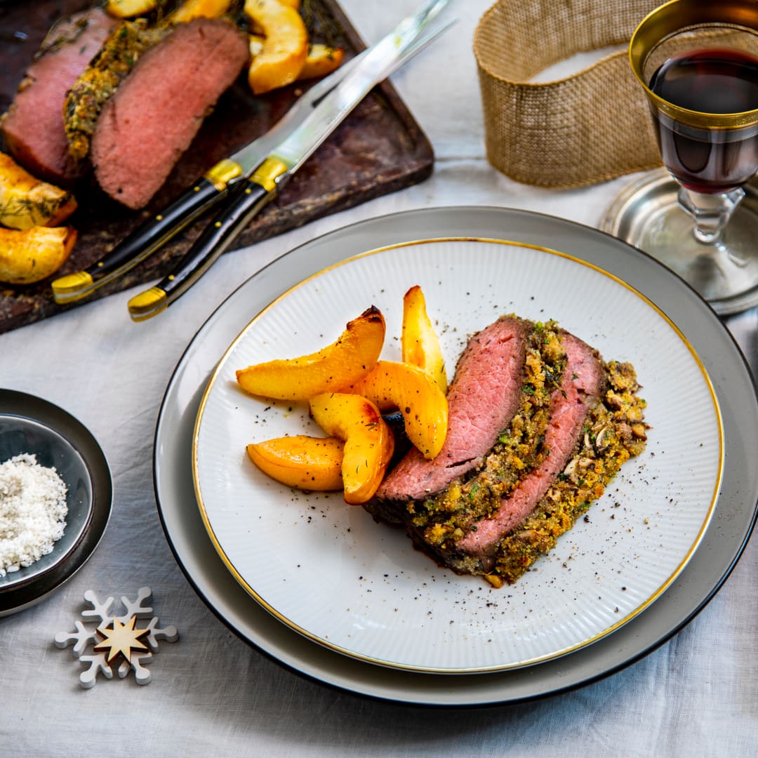 Weihnachtlichter geht es kaum! Unser Weihnachtsbraten kommt vom Hirsch und wird mit grünem Speck, Quitten und einer Kruste aus Champignons, Walnüssen und weihnachtlichen Gewürzen kombiniert: Wir wünschen ein frohes Fest!