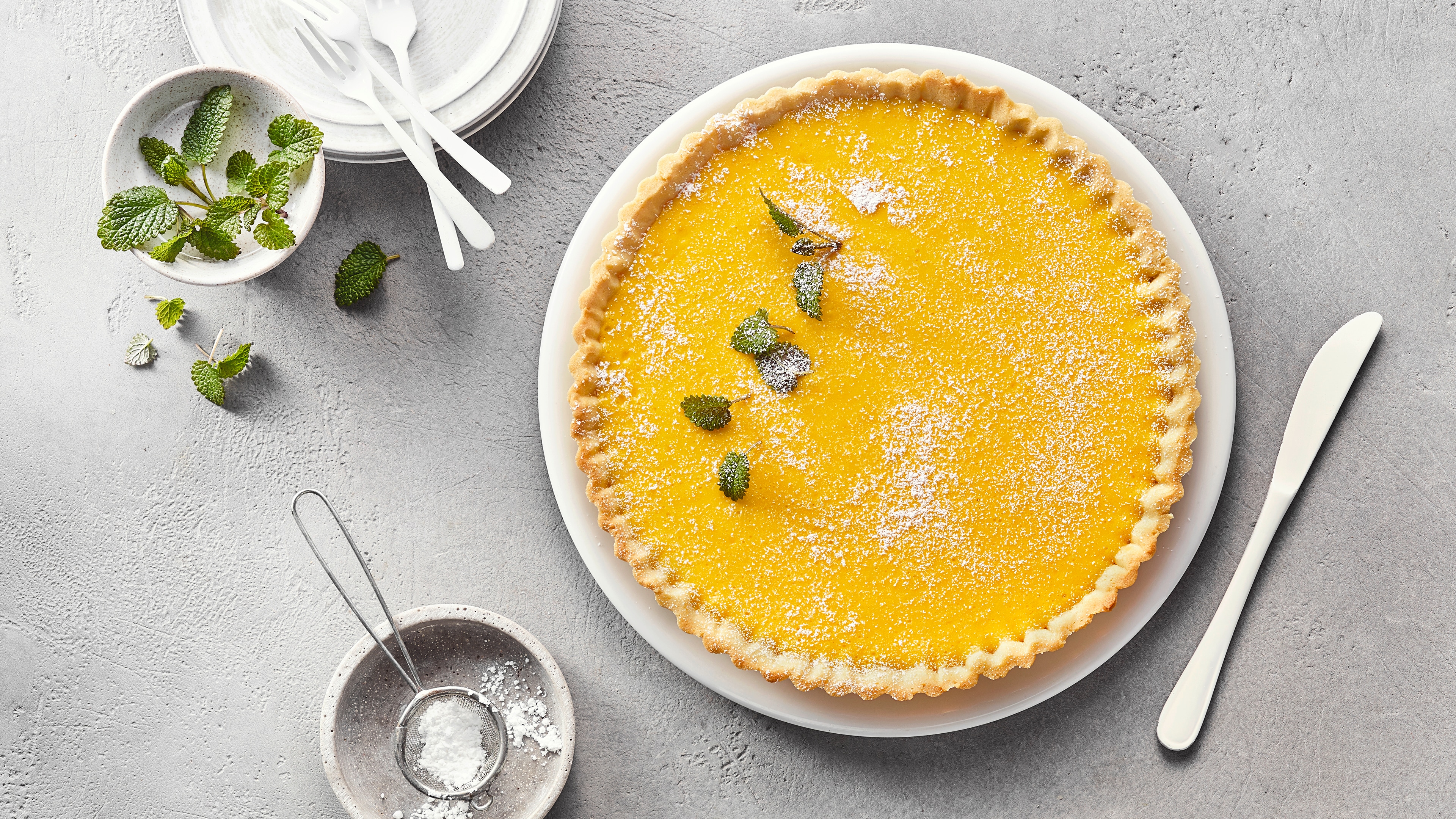 Große Tarte mit gelblicher Creme auf Teller