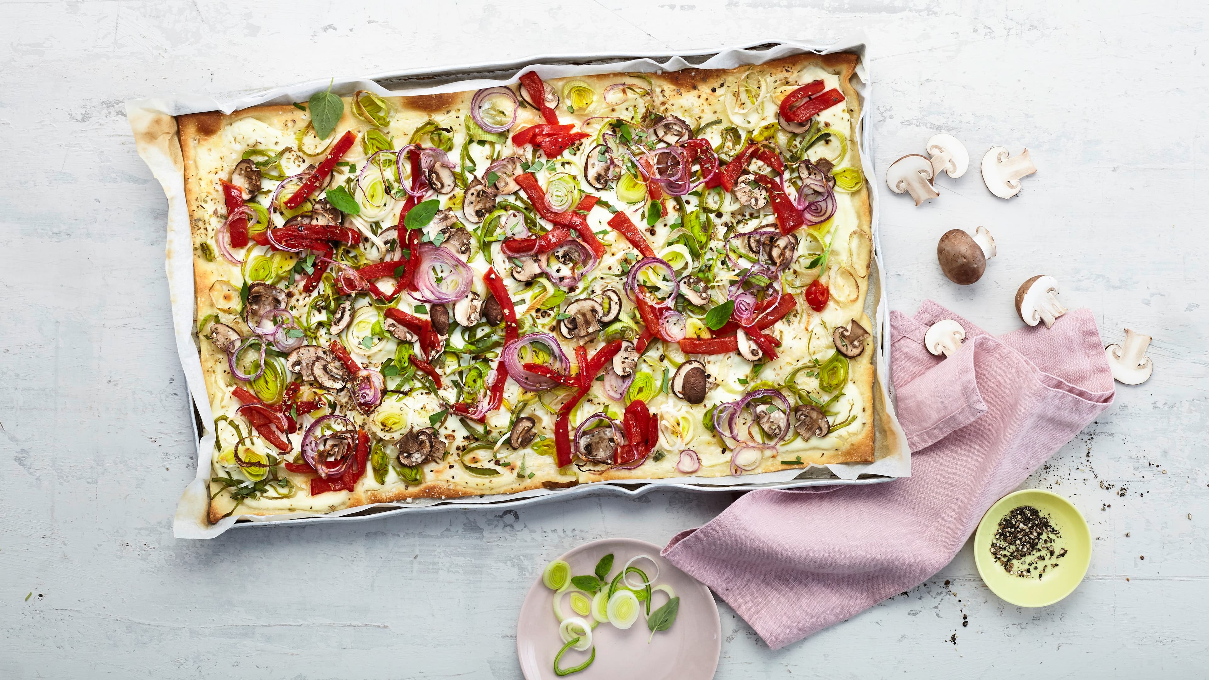 Veggie-Flammkuchen Lust auf einen schnellen Snack mit Gemüse? Probieren Sie unseren Veggie-Flammkuchen mit Röstpaprika, Porree und Champignons auf Schmand-Belag mit Ziegenfrischkäse!