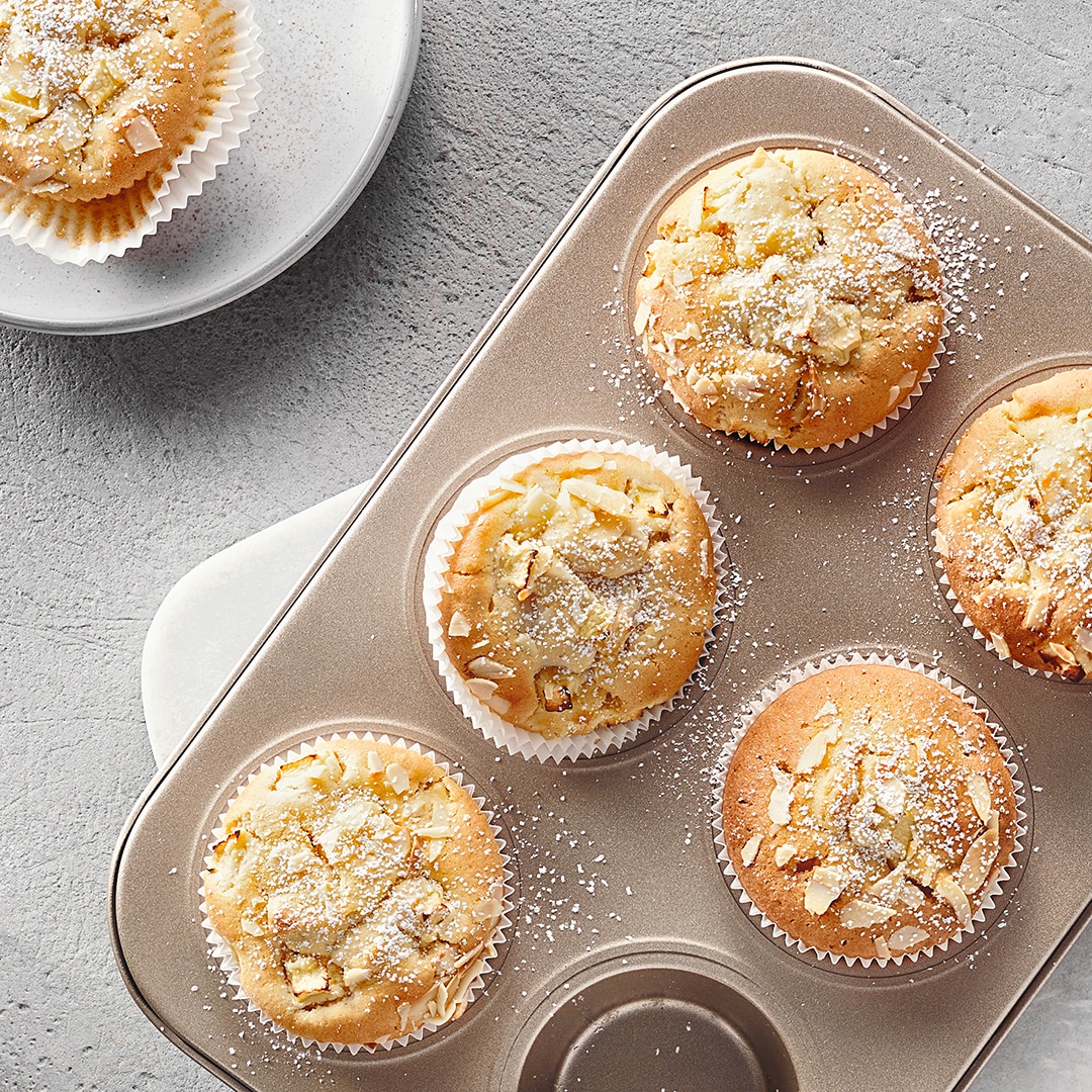 Muffins mit kleinen Apfelstückchen in Papierförmchen in Muffinform
