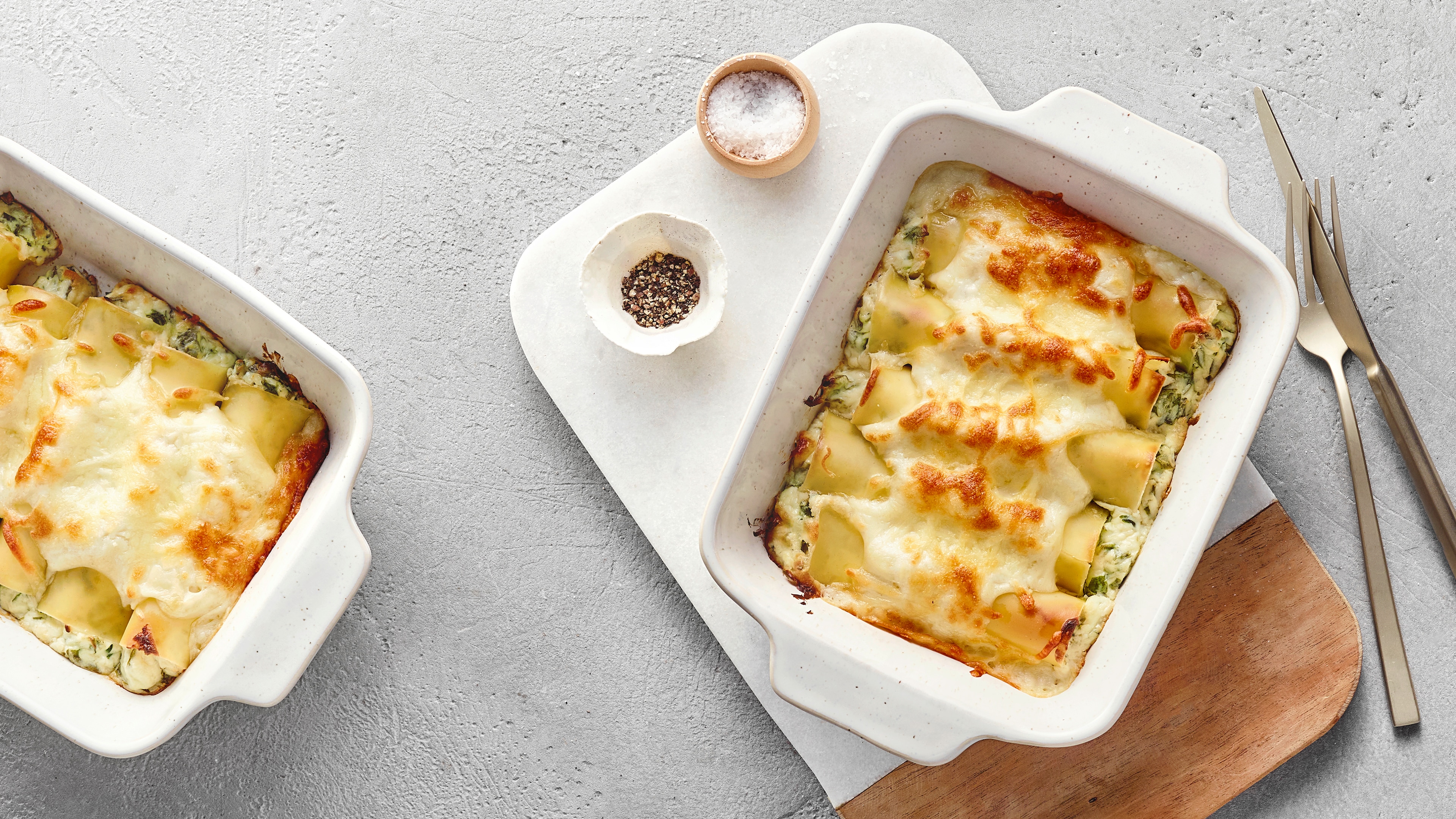 Mit Käse überbackene Cannelloni mit glatter, heller Oberfläche, durch die eine grüne Bärlauchfüllung leicht durchschimmert.