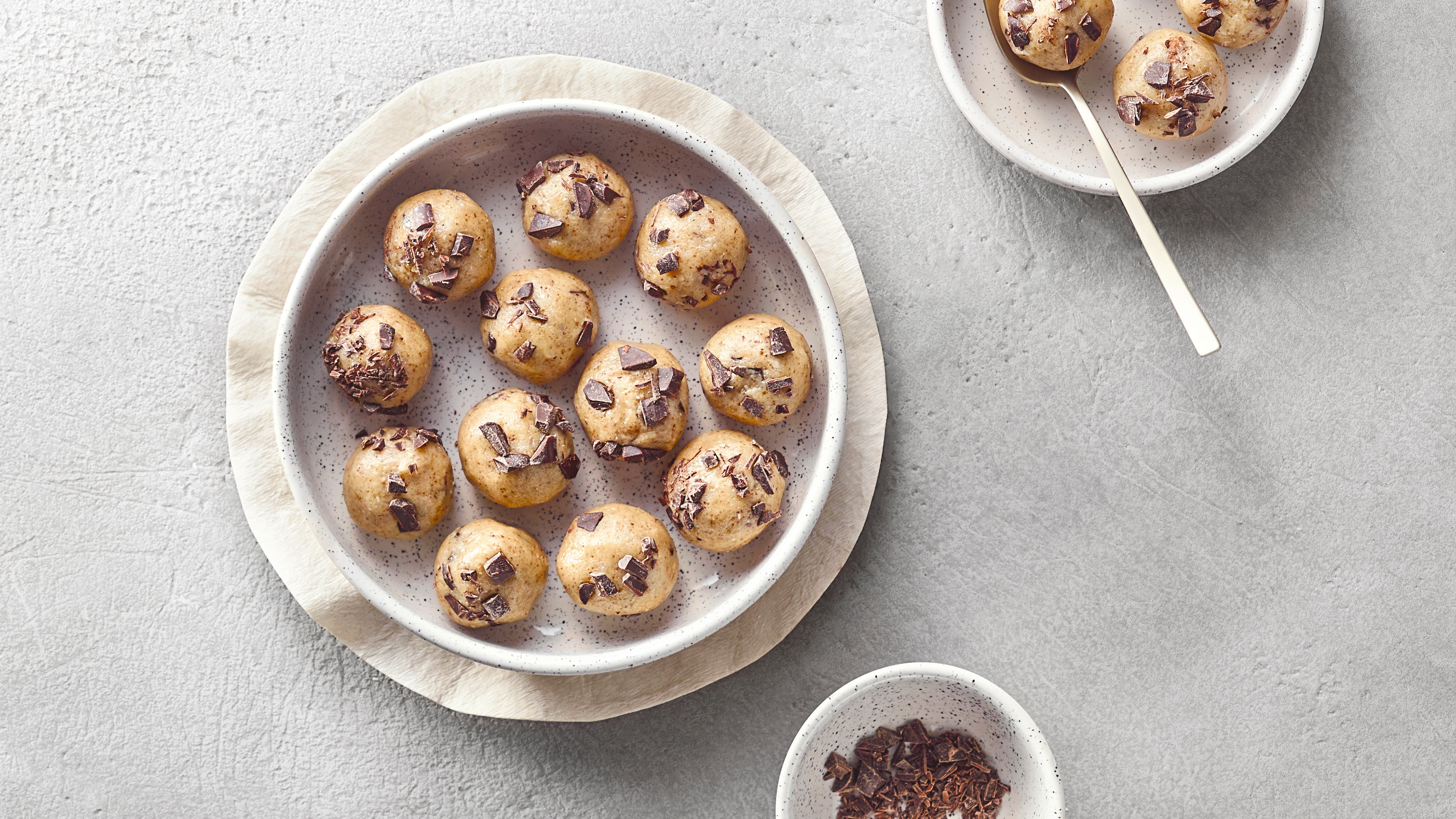 Schale mit mehreren rohen Teilbällchen mit Schokoladenstücken.