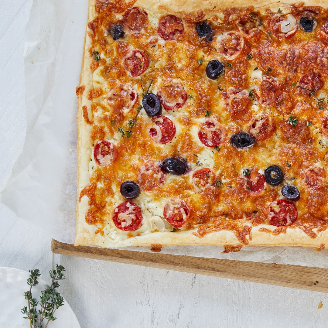 Pizza mit Tomatenscheiben und Olivenstücken
