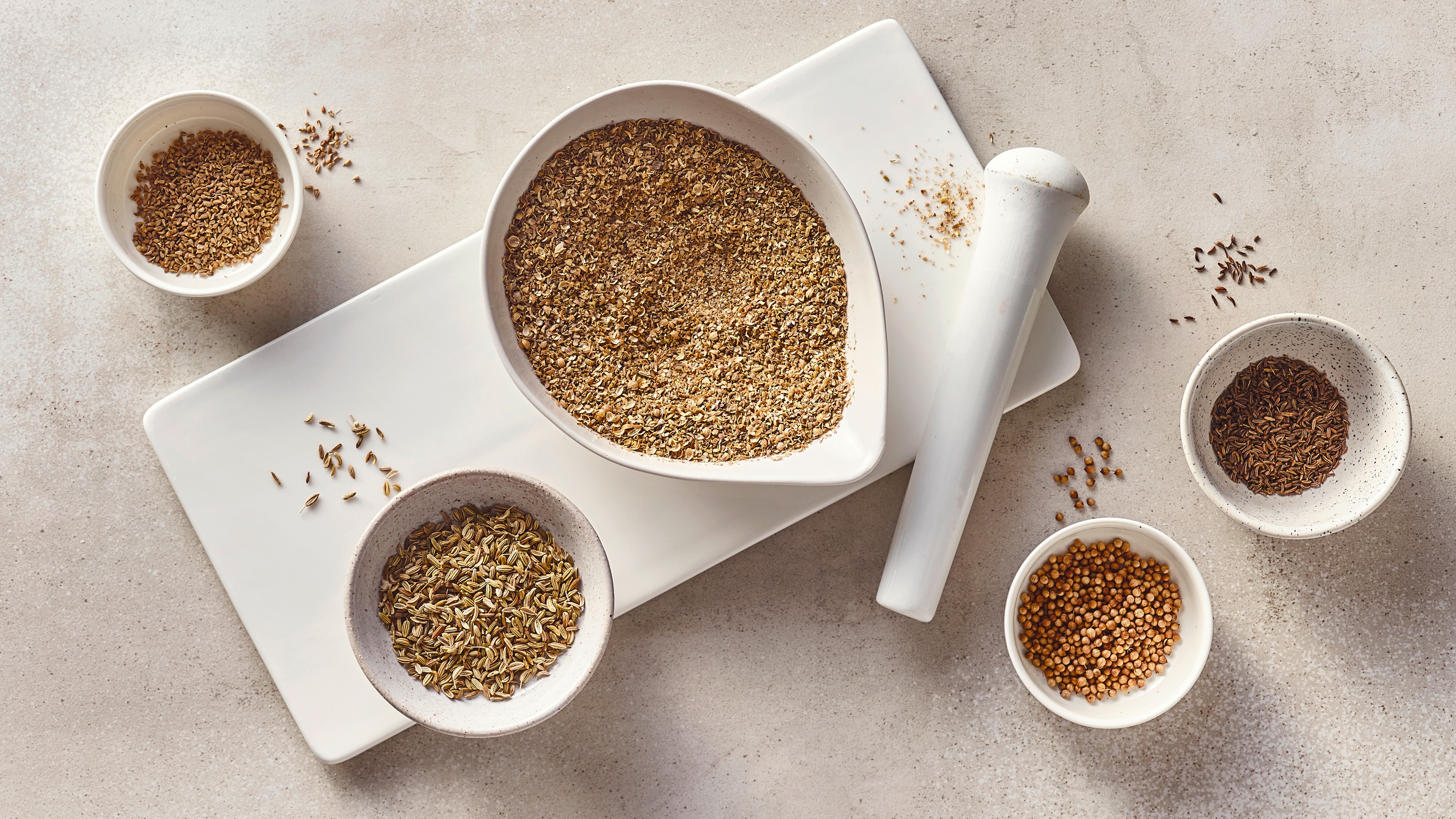 Rezept für selbst gemachtes Brotgewürz Eine Schale mit einer Gewürzmischung, daneben kleine Schälchen mit Kreuzkümmel, Koriander, Fenchelsamen und Anis