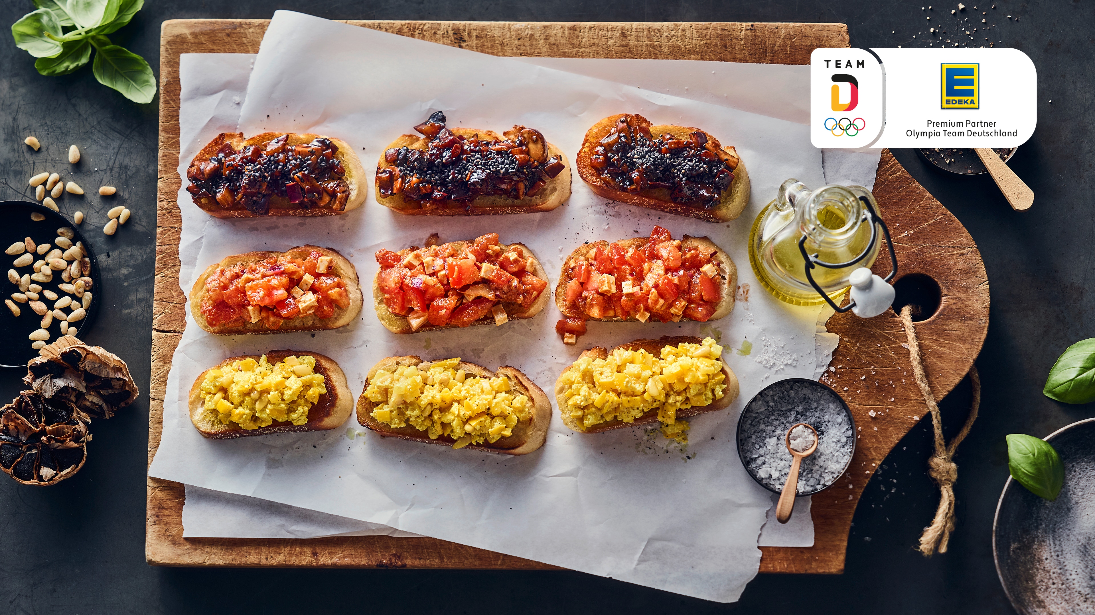 Rezept für Bruschetta mit dreierlei Belag Holzbrett mit 9 Baguettescheiben mit schwarzem, roten und gelbem Belag
