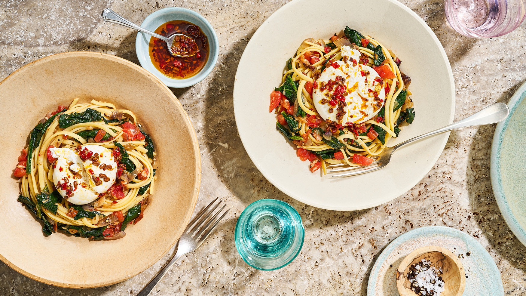 Rezept für Chili-Linguine mit Spinat und Burrata 2 Teller mit einem Nudelgericht mit Spinat und gewürzten Burrata-Kugeln