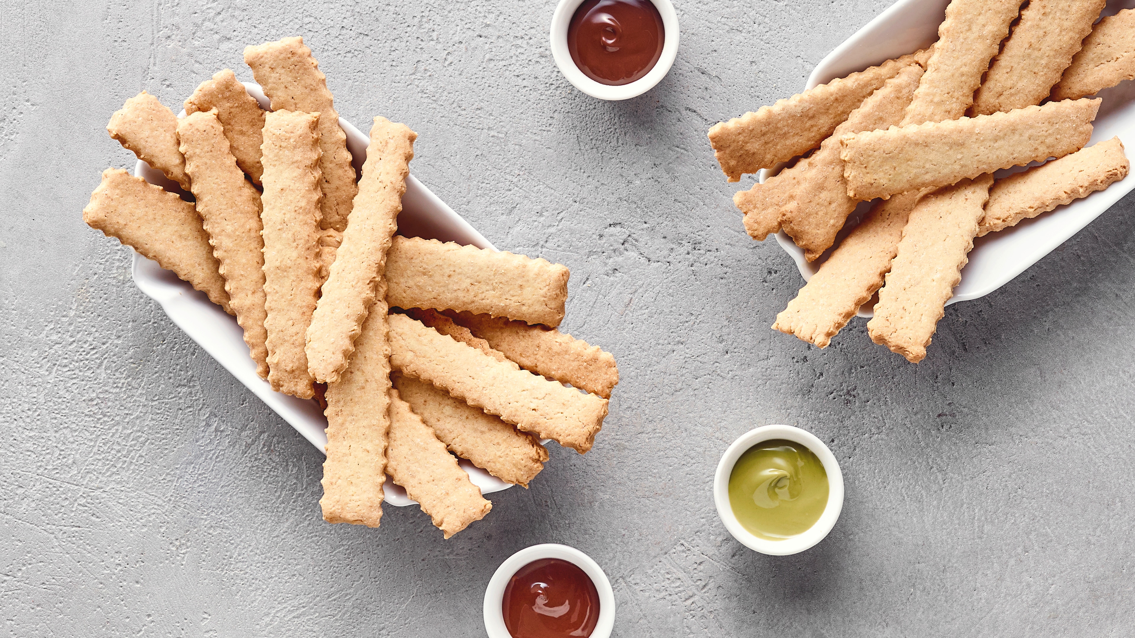 In Streifen geschnittene, goldbraune Cookie‑Sticks, serviert wie Pommes in kleinen Schalen.