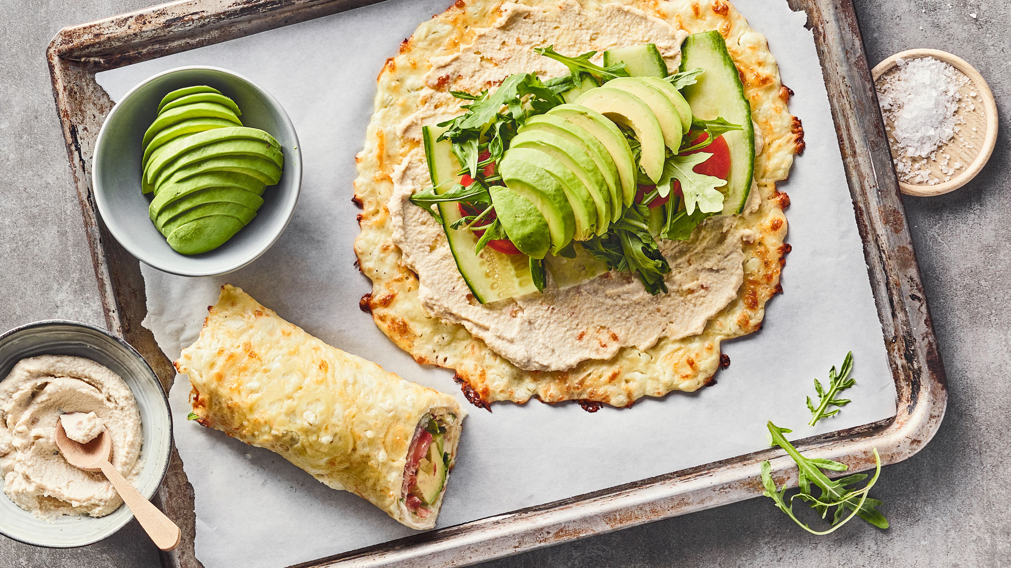 Rezept für Cottage Cheese Wraps Ein Blech mit Hüttenkäse-Wraps mit Streichcreme, Gurke, Tomate, Rucola und Avocado