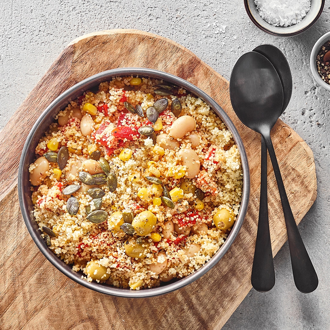 Große Schale mit krümeligem Couscous, Bohnen, Mais und Kürbiskernen