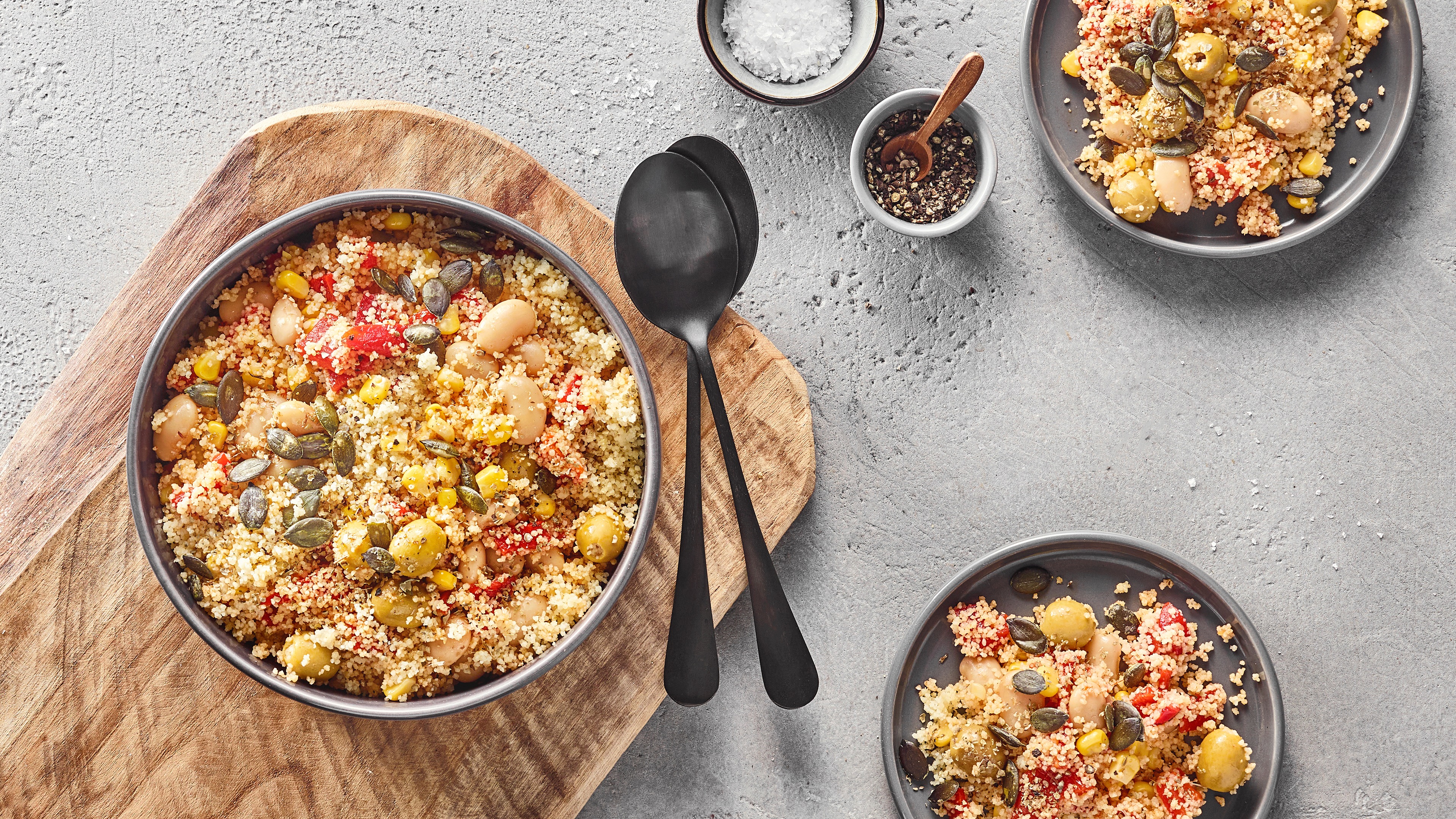 Große Schale mit krümeligem Couscous, Bohnen, Mais und Kürbiskernen