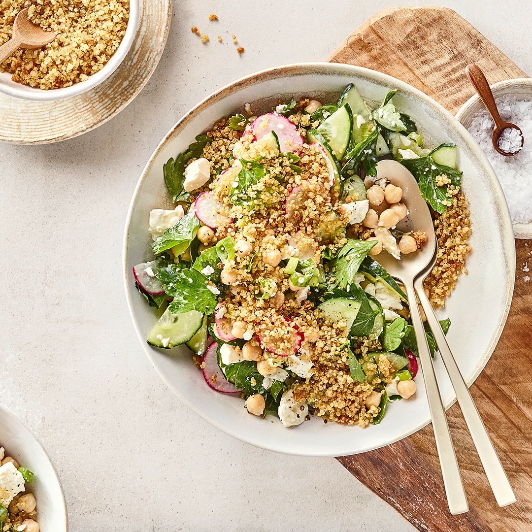 Quinoa-Salat mit Kichererbsen, Gurke, Radieschen und Feta in einer Schüssel.
