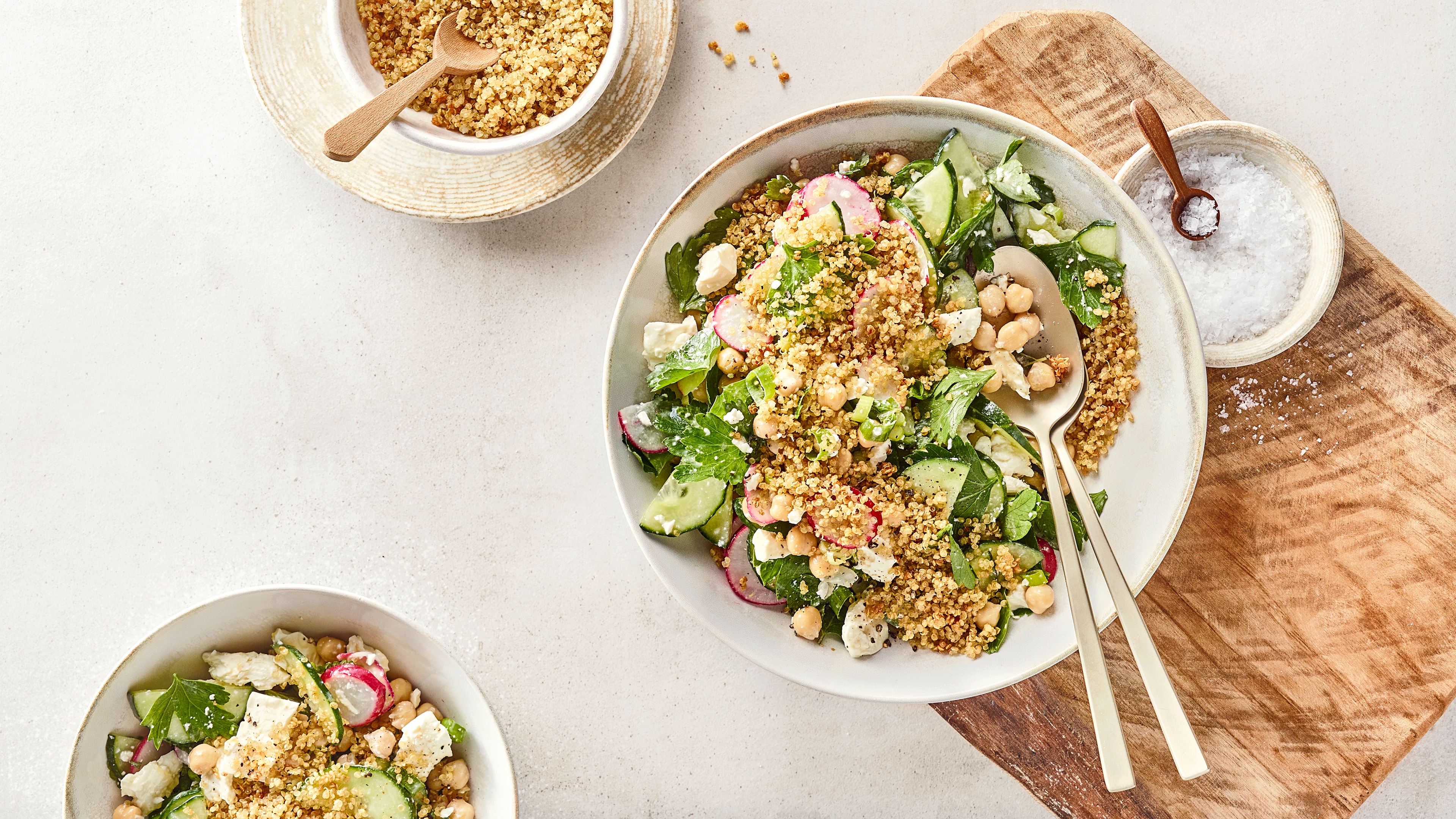 Quinoa-Salat mit Kichererbsen, Gurke, Radieschen und Feta in einer Schüssel.
