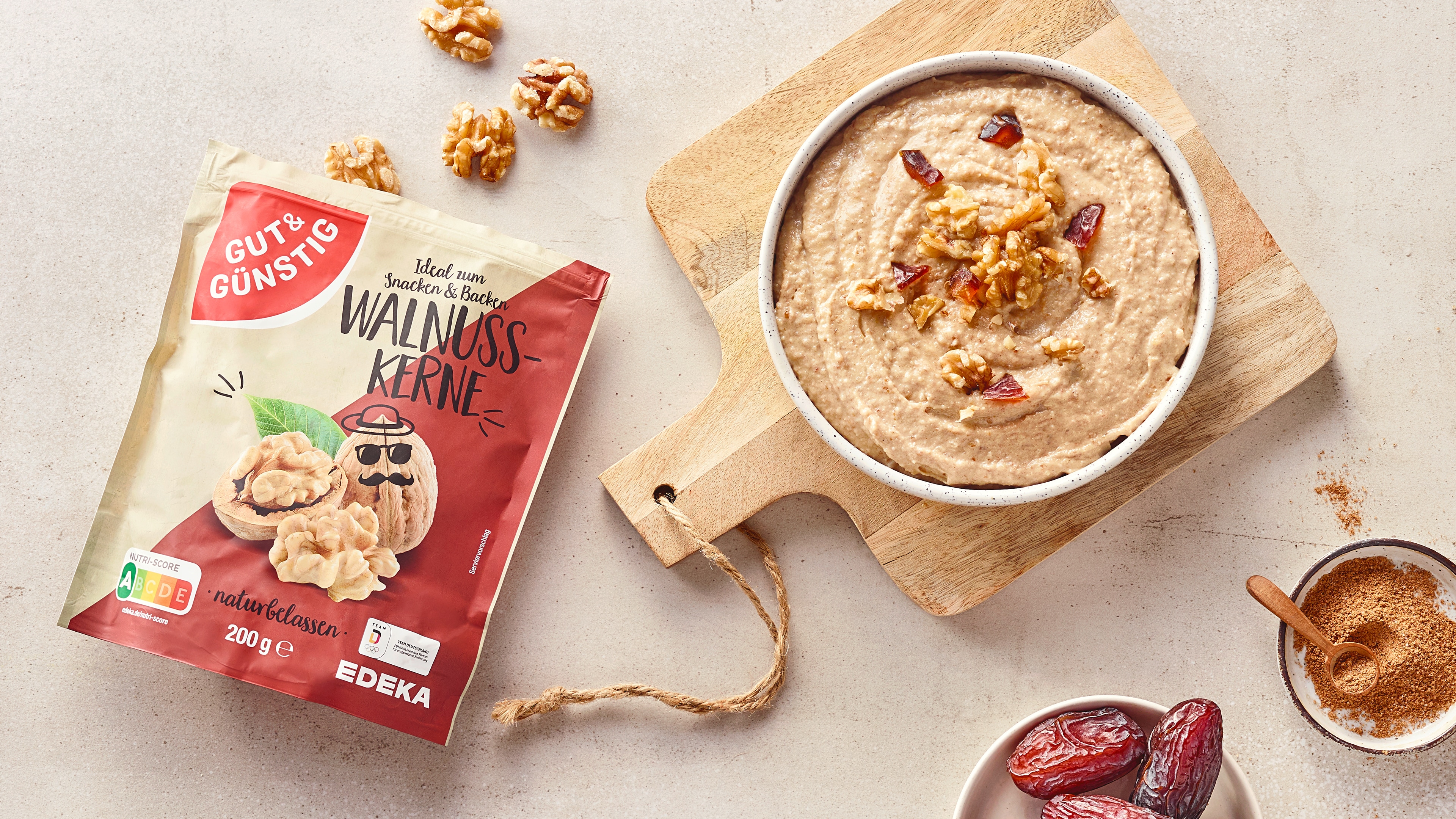 Rezept für Dattel-Walnuss-Dip mit Gut&Günstig Walnusskernen Eine Schale mit einem cremigen, hellen Dip, garniert mit Datteln & Walnüssen, daneben eine Packung Gut&Günstig Walnusskerne