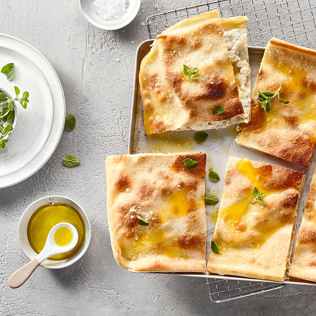 Dünne, rechteckige Brotfladenstücke, daneben ein Schälchen mit Öl