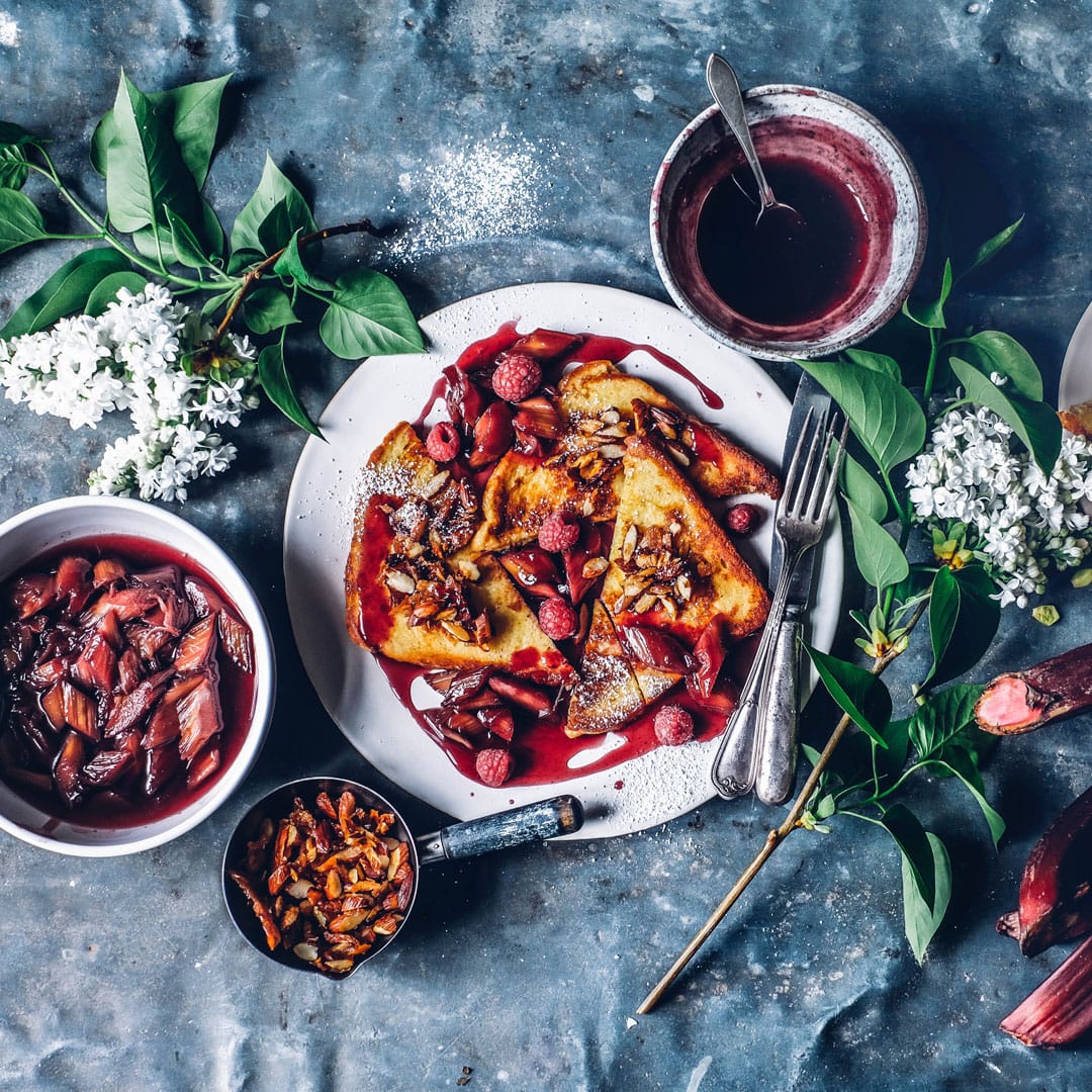 Ein fantastisches Frühstück, das den Start in den Tag zu etwas ganz Besonderem macht: Kokos-Mandel-French-Toast mit pochiertem Rhabarber und Himbeeren.