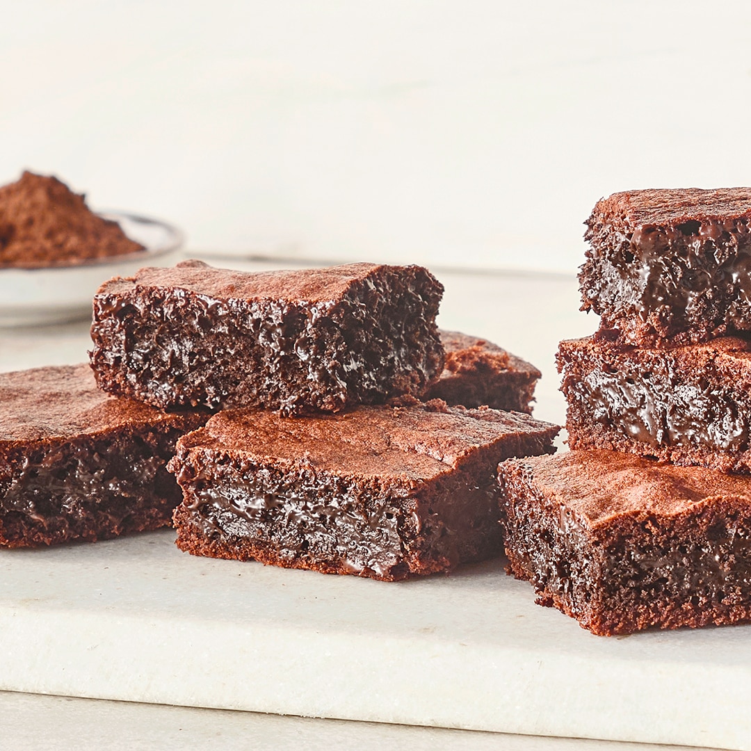 Ein Teller mit mehreren braunen Schokoladenstücken, die innen glänzen und außen eine matte, gebackene Oberfläche haben.