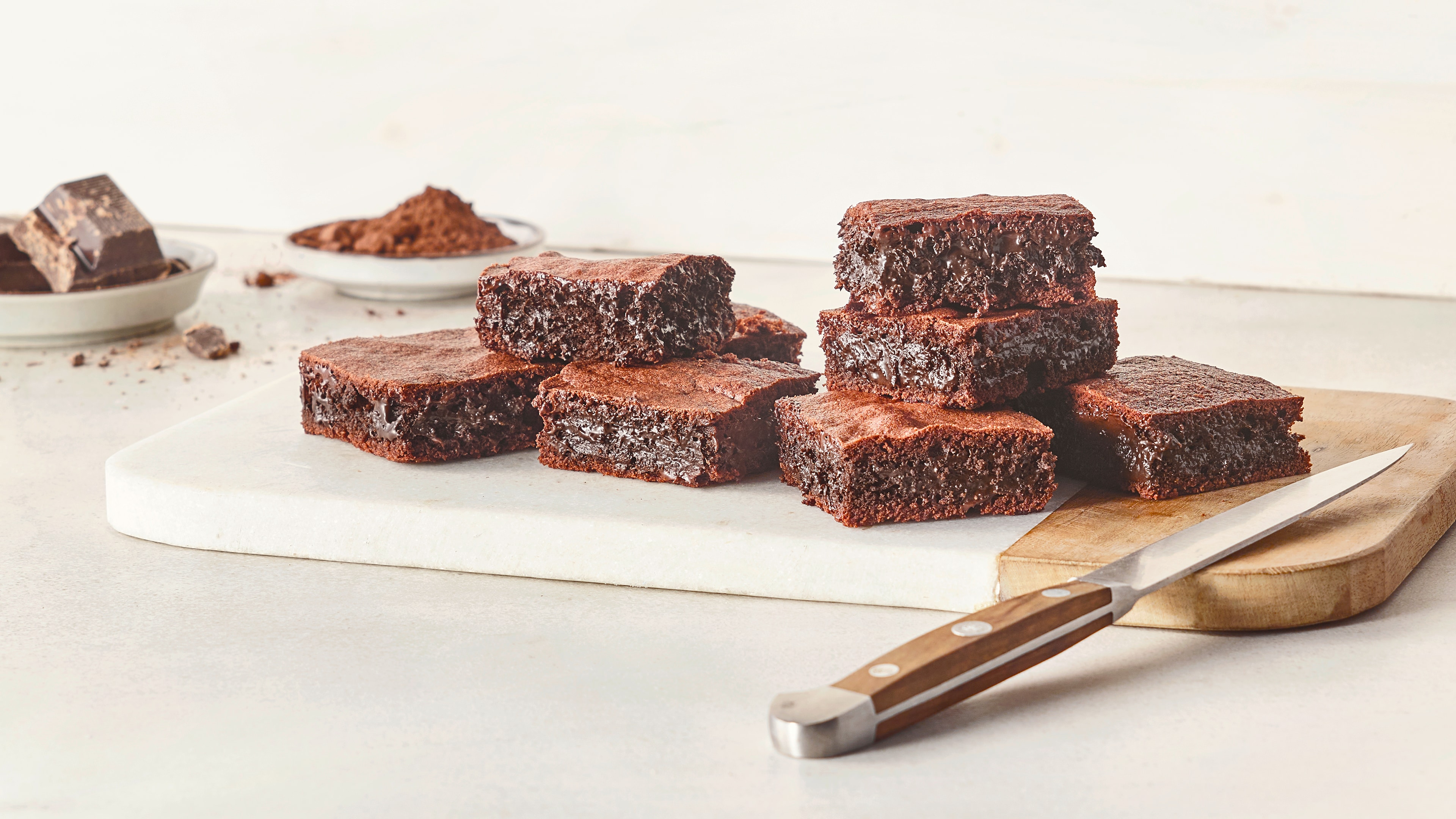 Ein Teller mit mehreren braunen Schokoladenstücken, die innen glänzen und außen eine matte, gebackene Oberfläche haben.