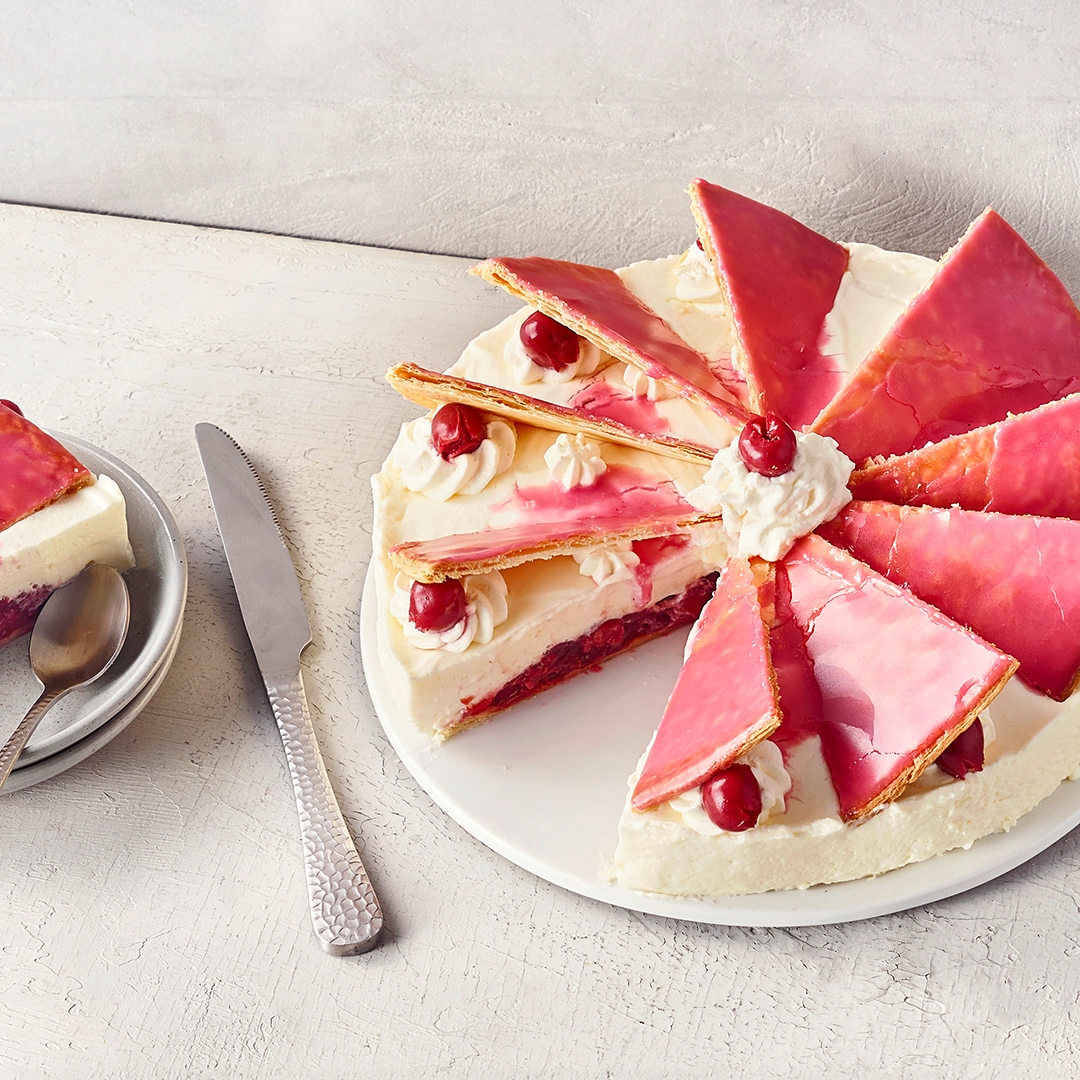 Cremige Torte mit Kirschfüllung und glasierten Blätterteigdreiecken