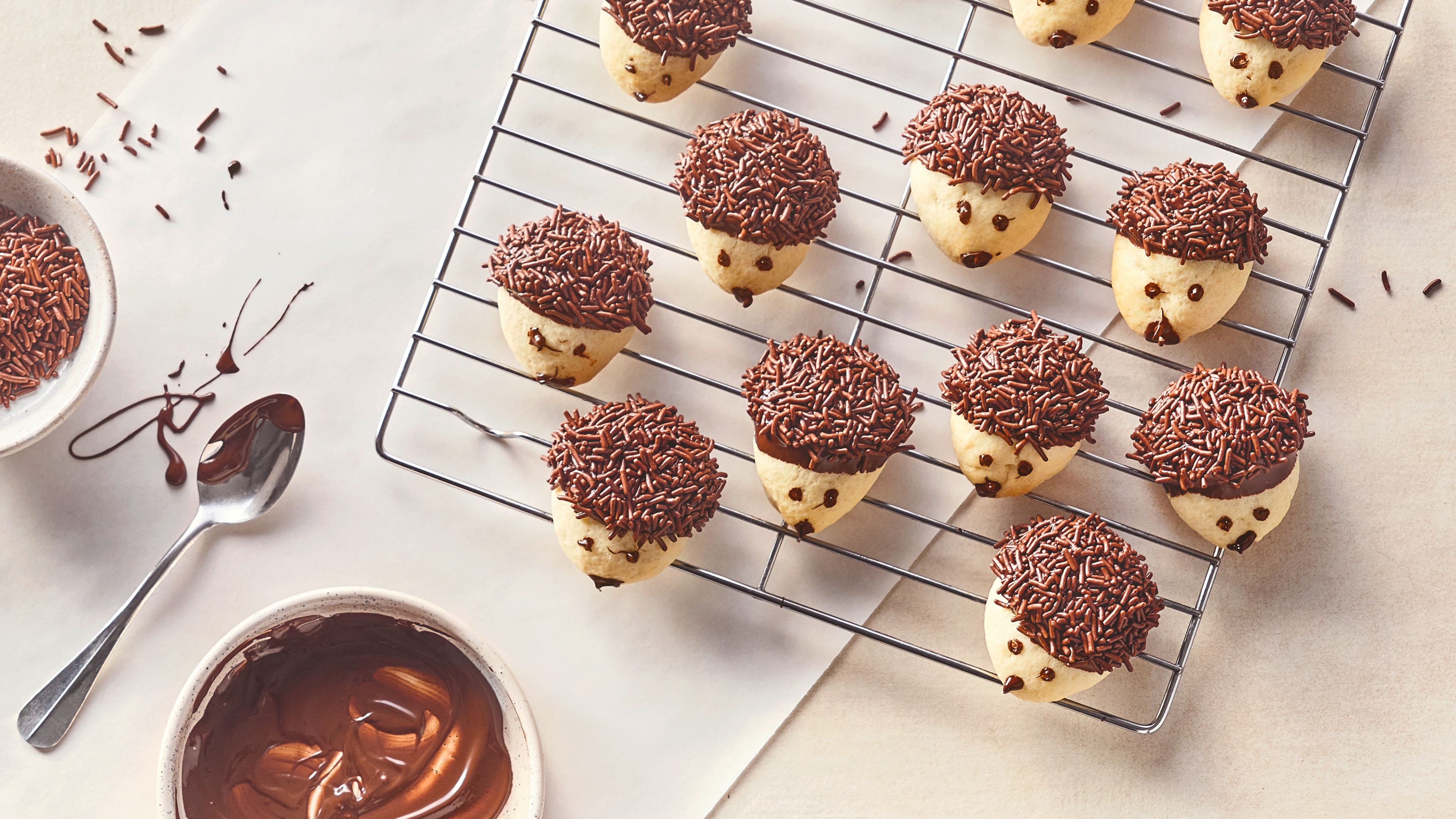 Rezept für Igelkekse Helle Butterkekse mit Augen und Nase aus Schokolade sowie Stacheln aus Schokolade und Schokostreuseln, auf einem Abkühlgitter