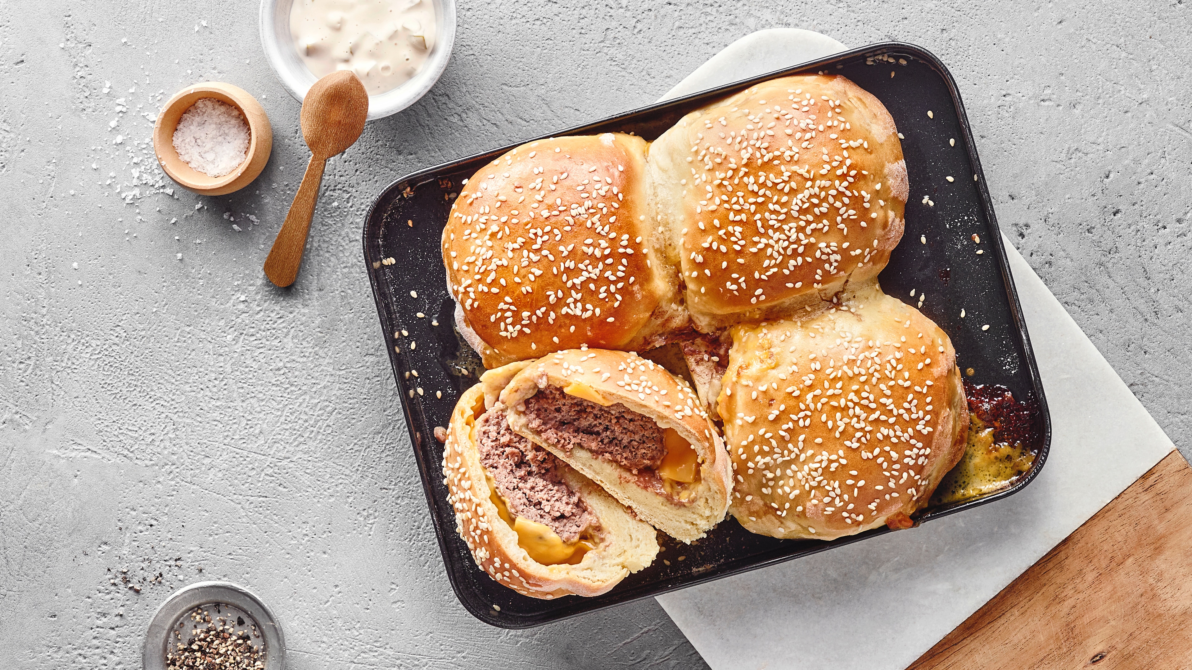 Vier in Teig eingebackene Burger, goldbraun gebacken, gefüllt mit Rindfleisch und geschmolzenem Käse.