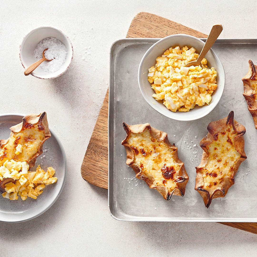 Blech mit dünnen Teigfladen, daneben Schälchen mit stückigem Dip