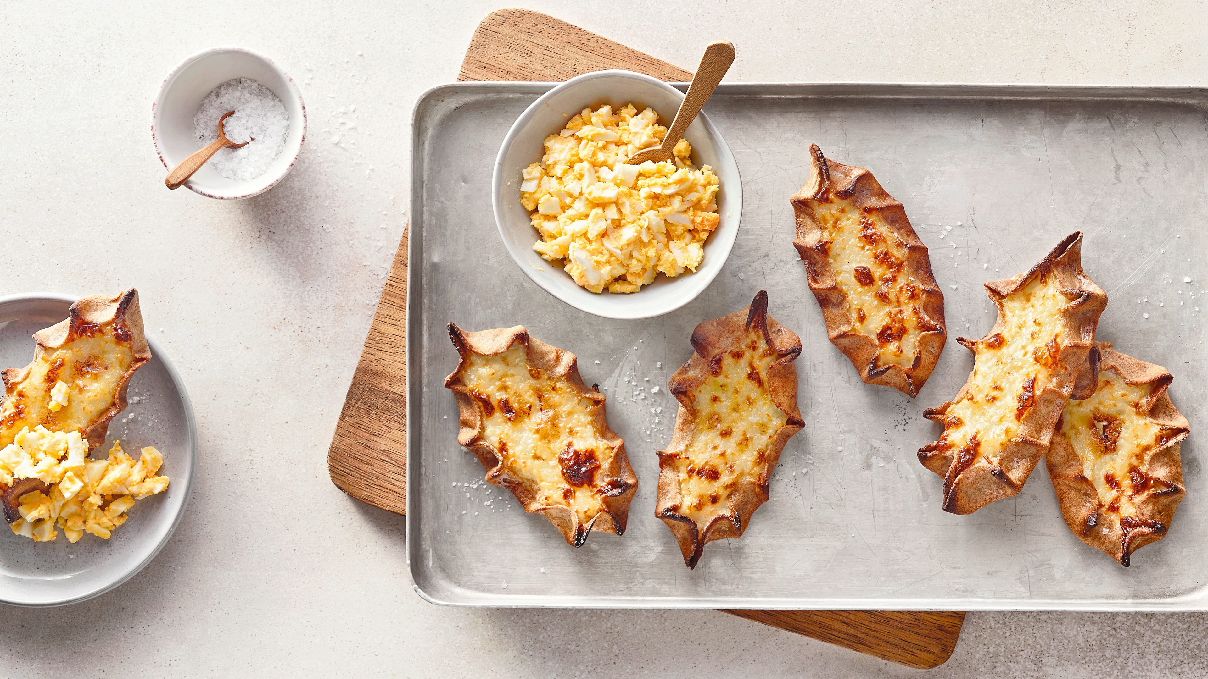 Blech mit dünnen Teigfladen, daneben Schälchen mit stückigem Dip