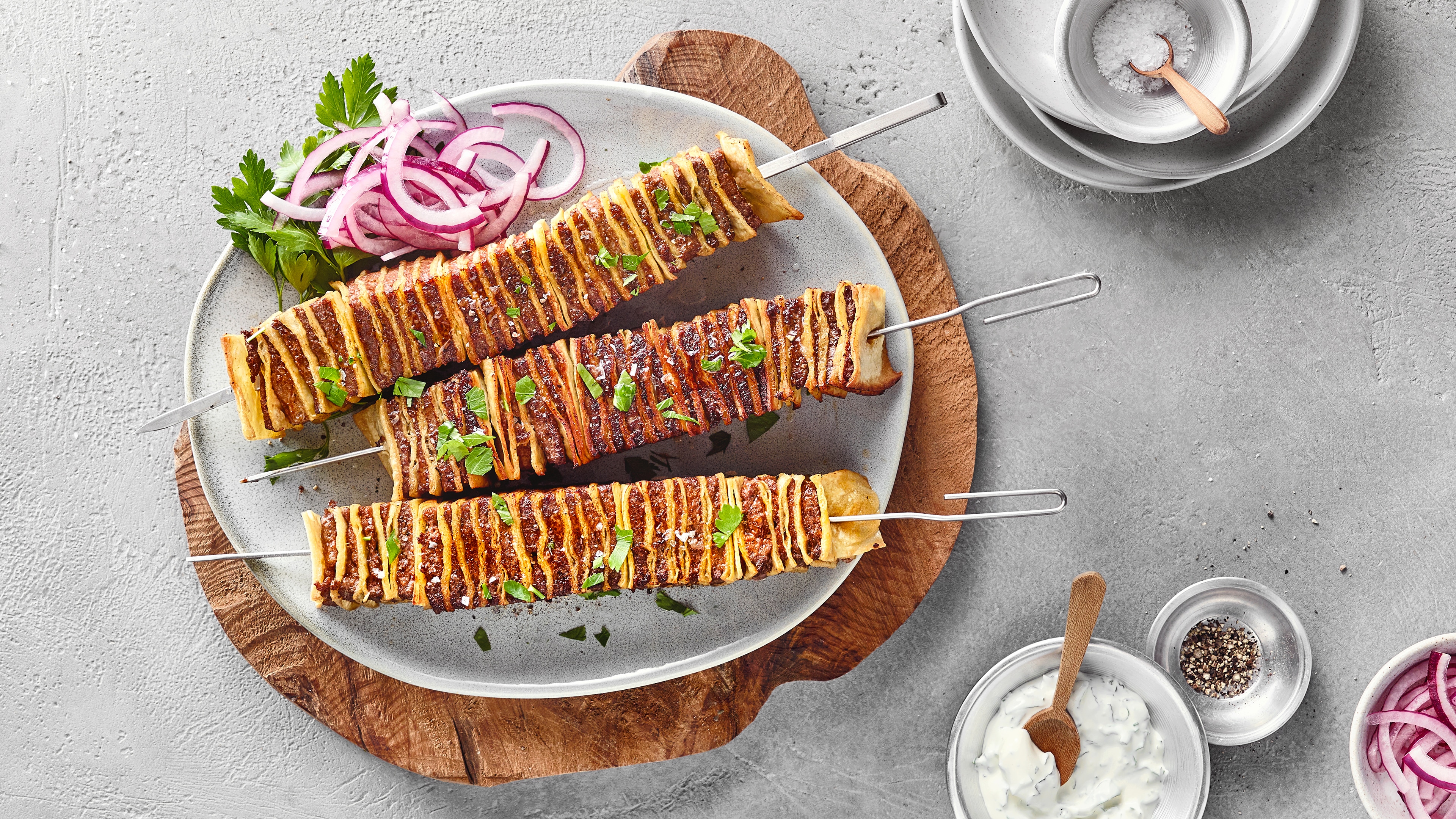 Drei Schaschlikspieße mit abwechselnd aufgespießtem Wrap und Hackfleisch.