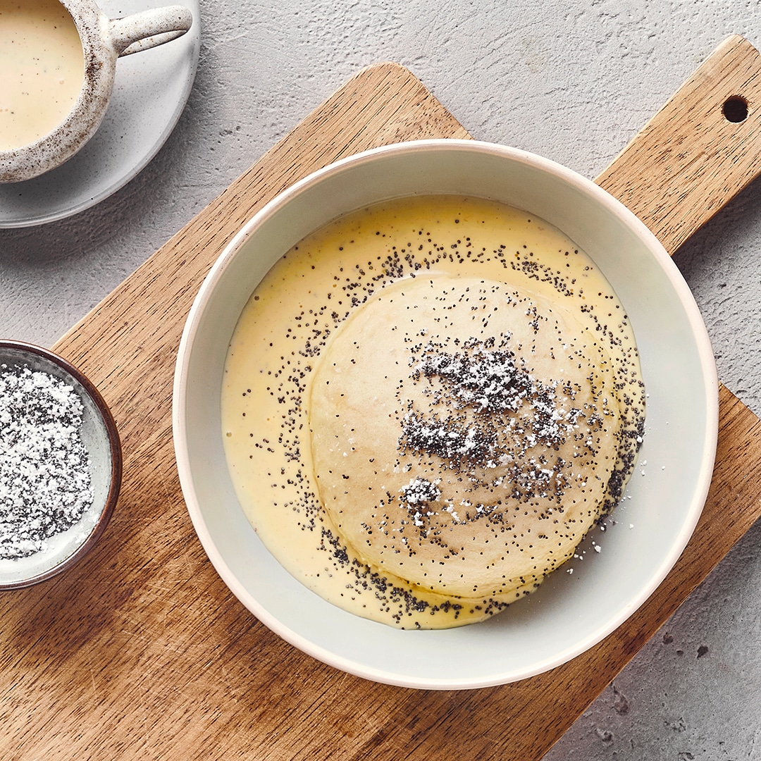 Ein Teller, gefüllt mit einem Teigkloß in Vanillesoße, garniert mit Moon.
