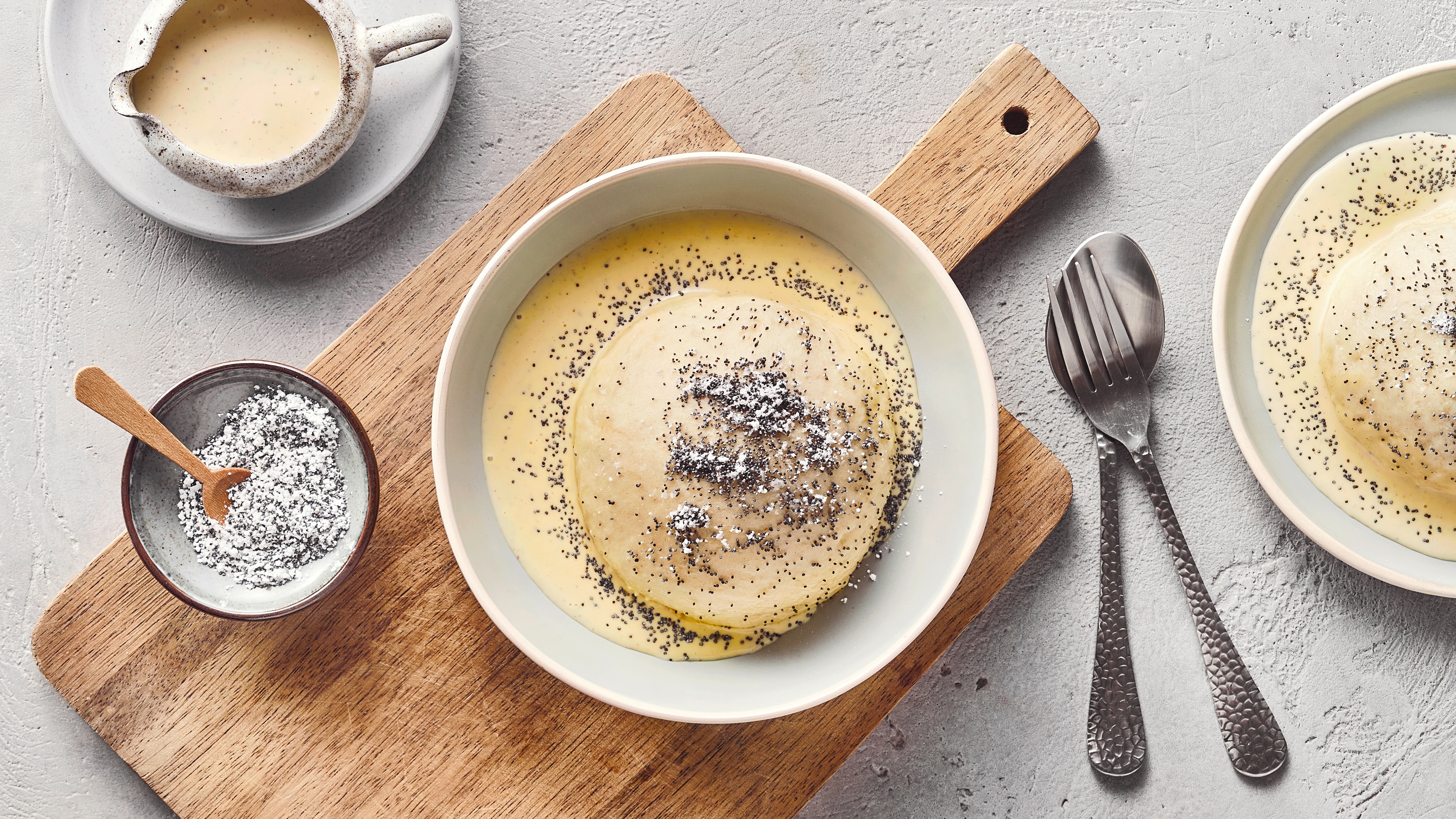 Ein Teller, gefüllt mit einem Teigkloß in Vanillesoße, garniert mit Moon.