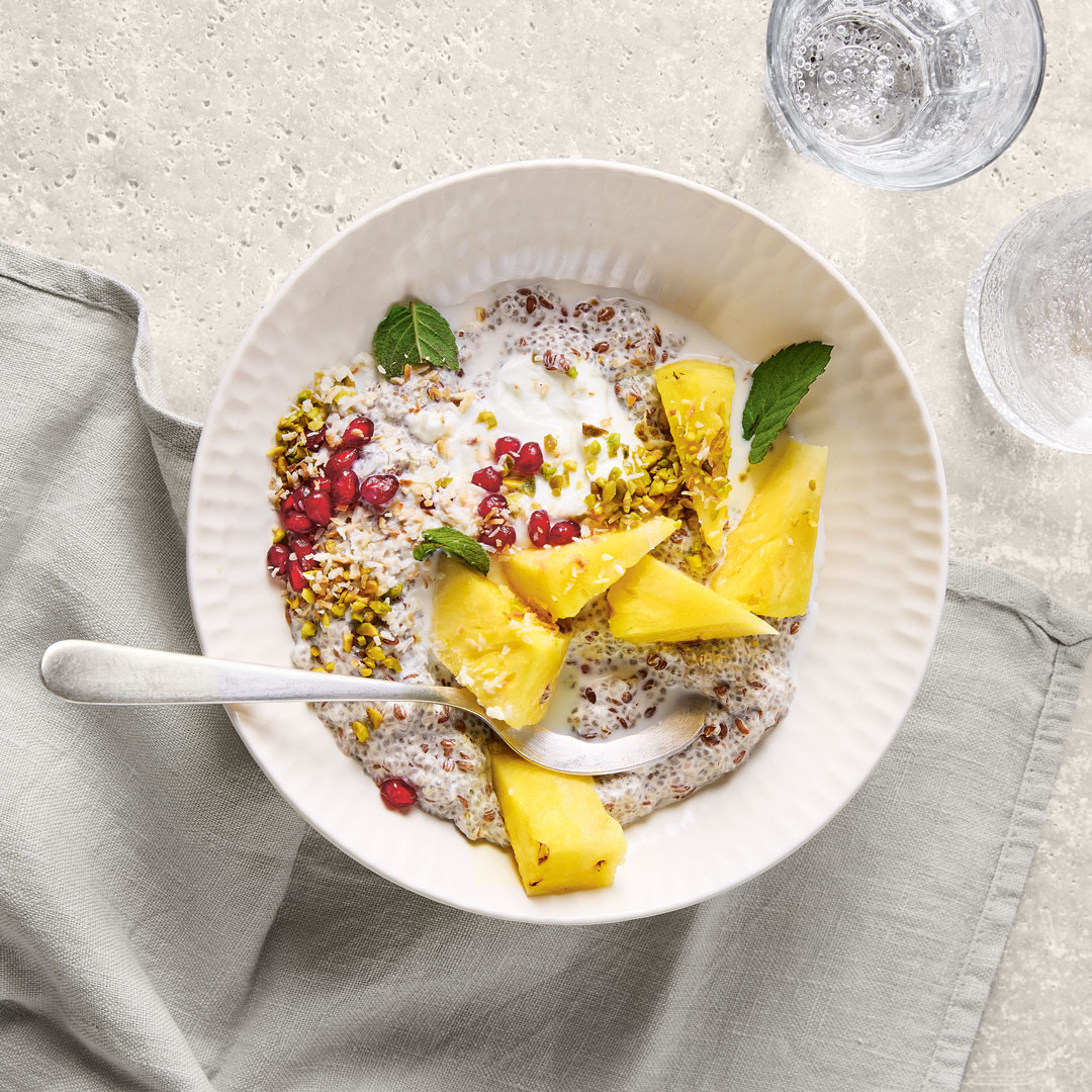 Schale mit hellem Chia-Pudding, Ananasstücken und Granatapfelkernen