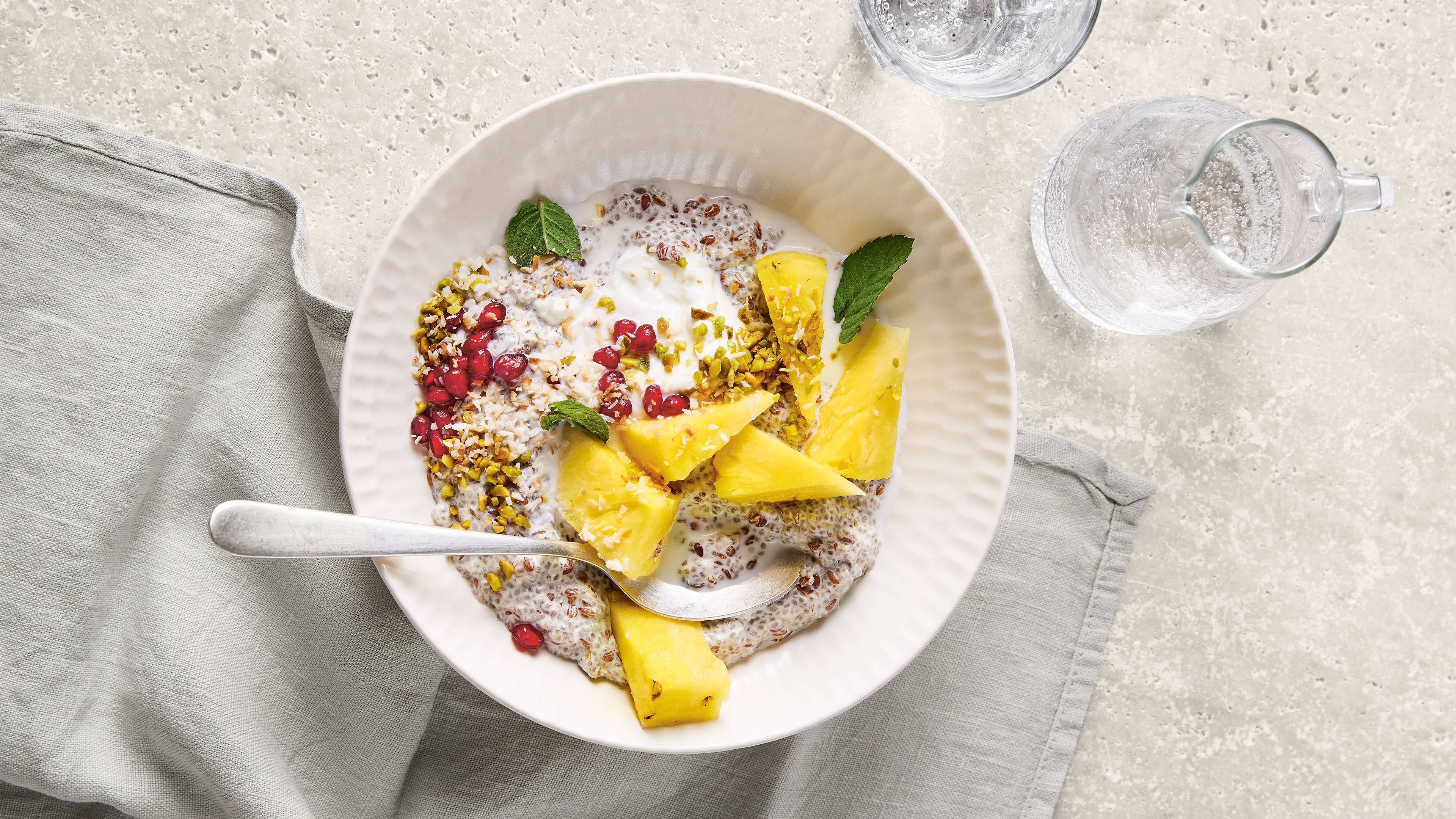 Schale mit hellem Chia-Pudding, Ananasstücken und Granatapfelkernen