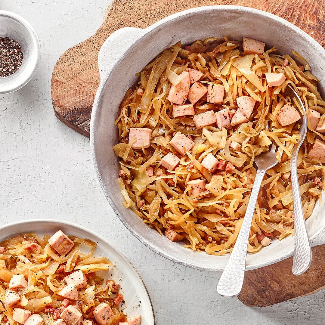 Krautpfanne mit gebratenem Weißkohl, Fleisch und Gewürzen in einer Pfanne.