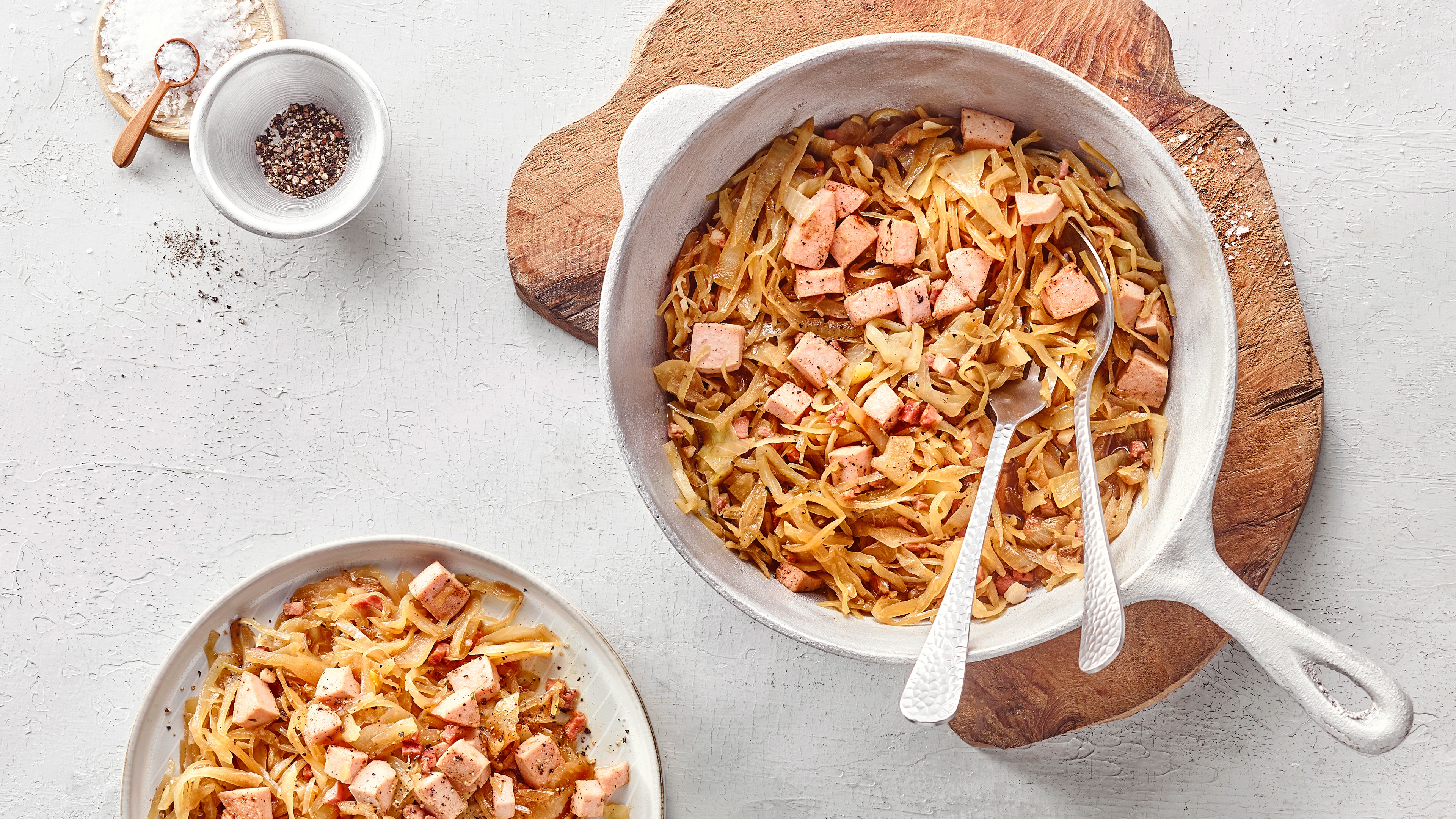 Krautpfanne mit gebratenem Weißkohl, Fleisch und Gewürzen in einer Pfanne.