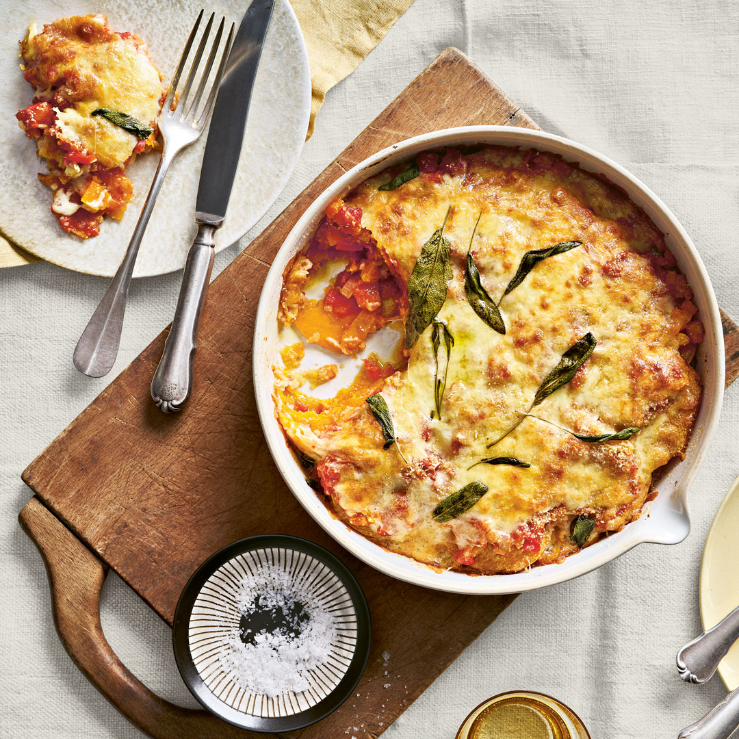 Runde Auflaufform mit Kürbisscheiben, roter Soße und Käse überbacken