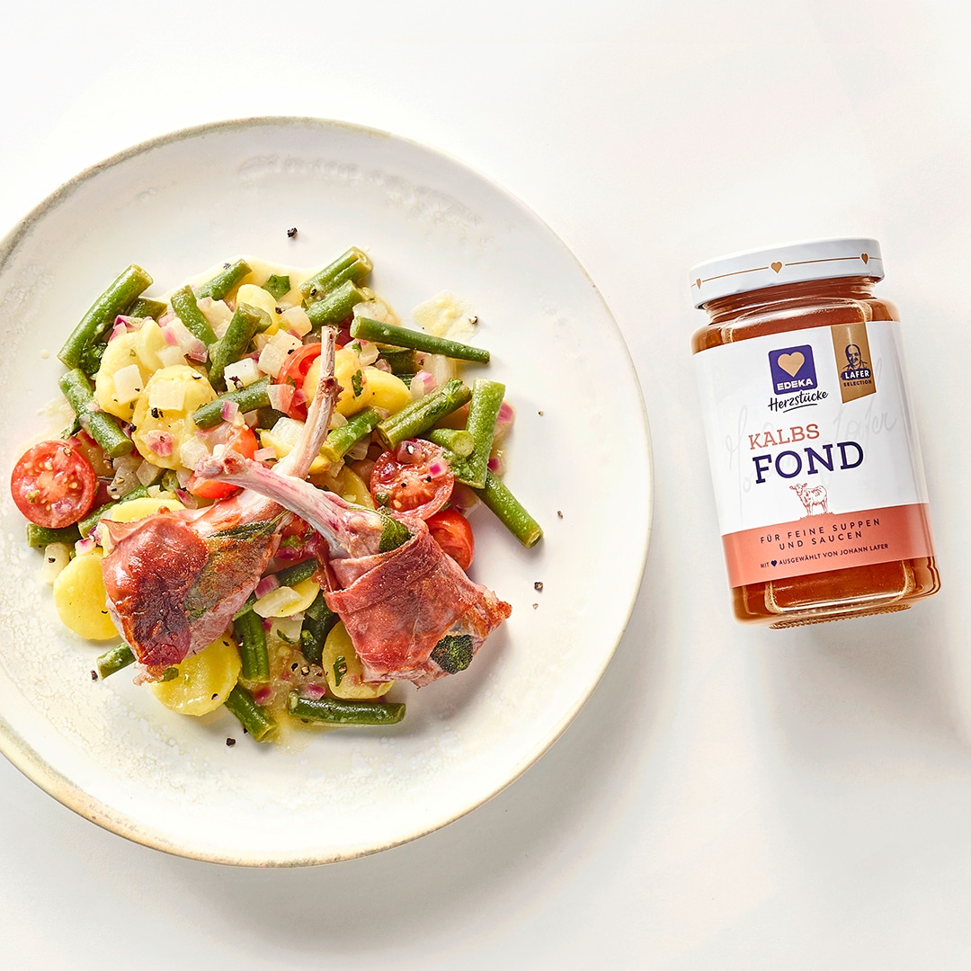 Kartoffelsalat mit grünen Bohnen, Cherrytomaten und gegrillten Lammkoteletts in einer Schale, daneben EDEKA Herzstücke Kalbsfond.
