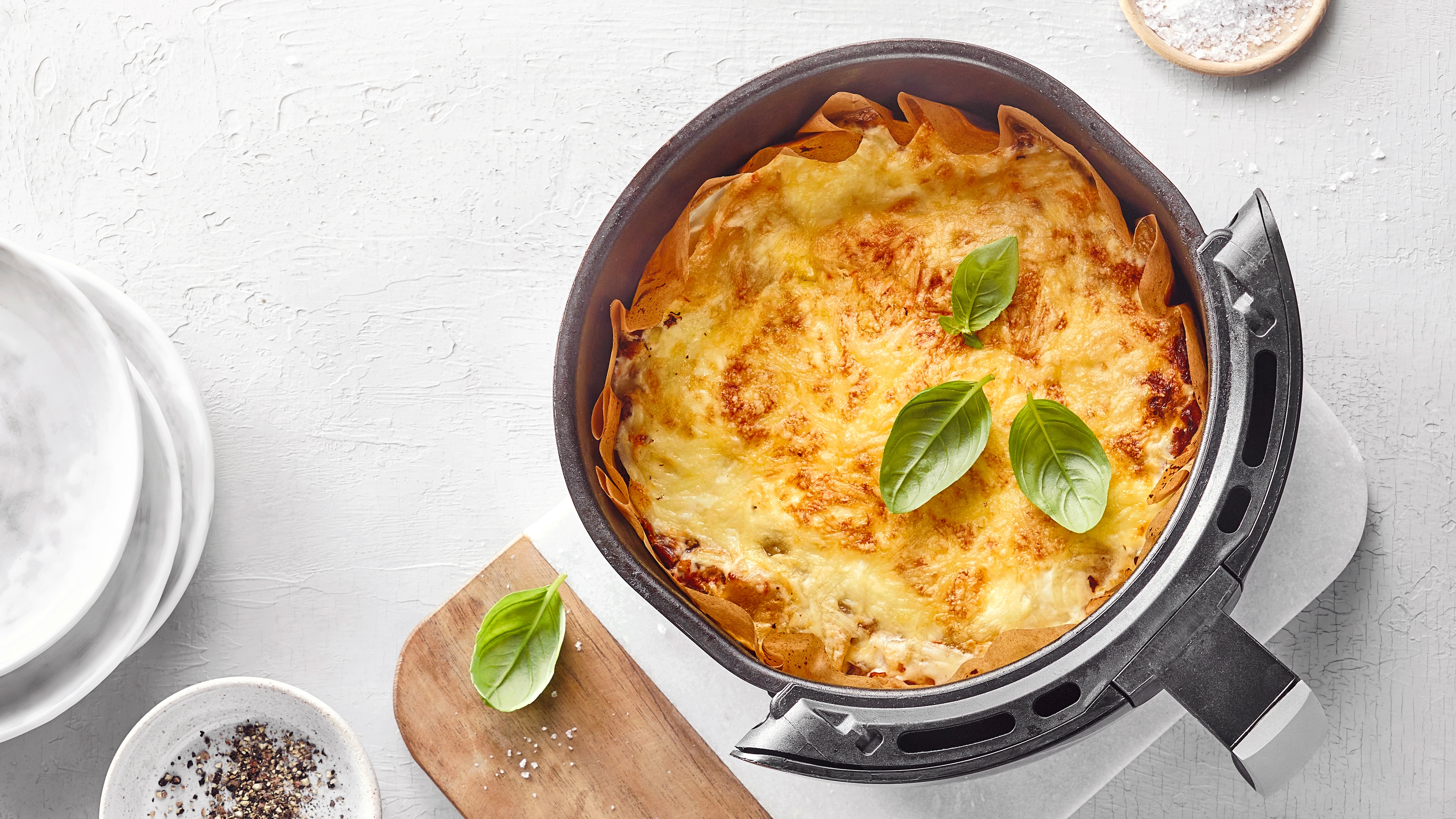 Airfryer mit Lasagneplatten, Hackfleisch und Käse.