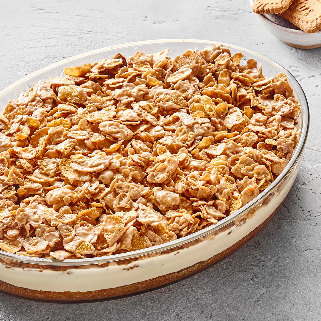 Schichtdessert aus zerbröselten Lotus‑Biscoff‑Keksen, cremiger Sahnefüllung und einem Keksboden in einer ovalen Glasform.