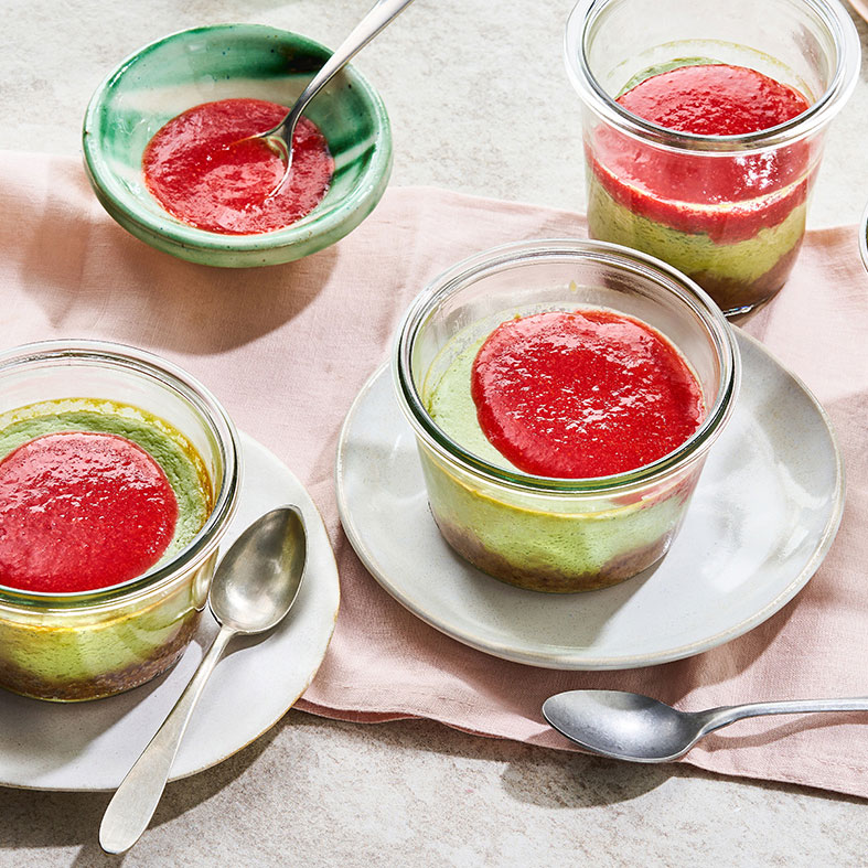 Kleine Dessertgläser mit grünlicher Creme und rotem Fruchtpüree