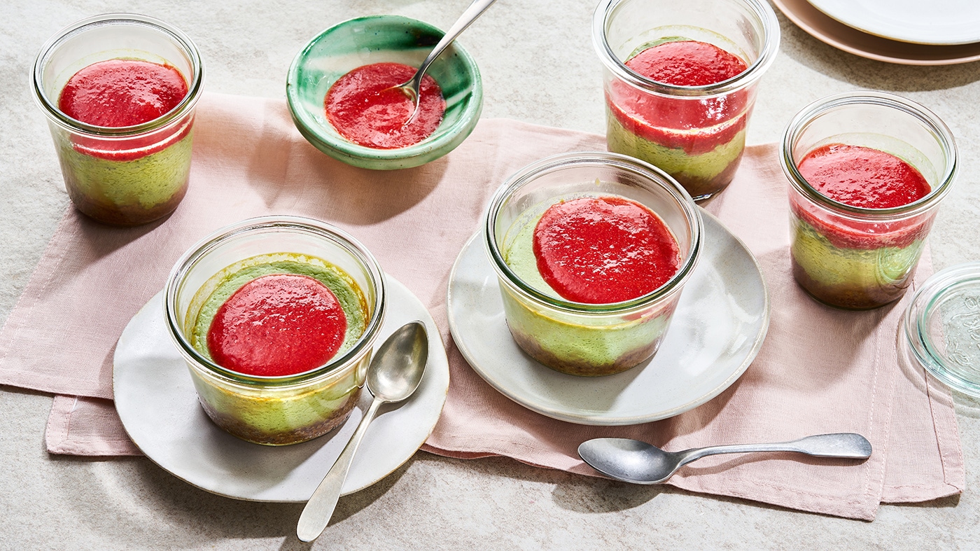 Kleine Dessertgläser mit grünlicher Creme und rotem Fruchtpüree