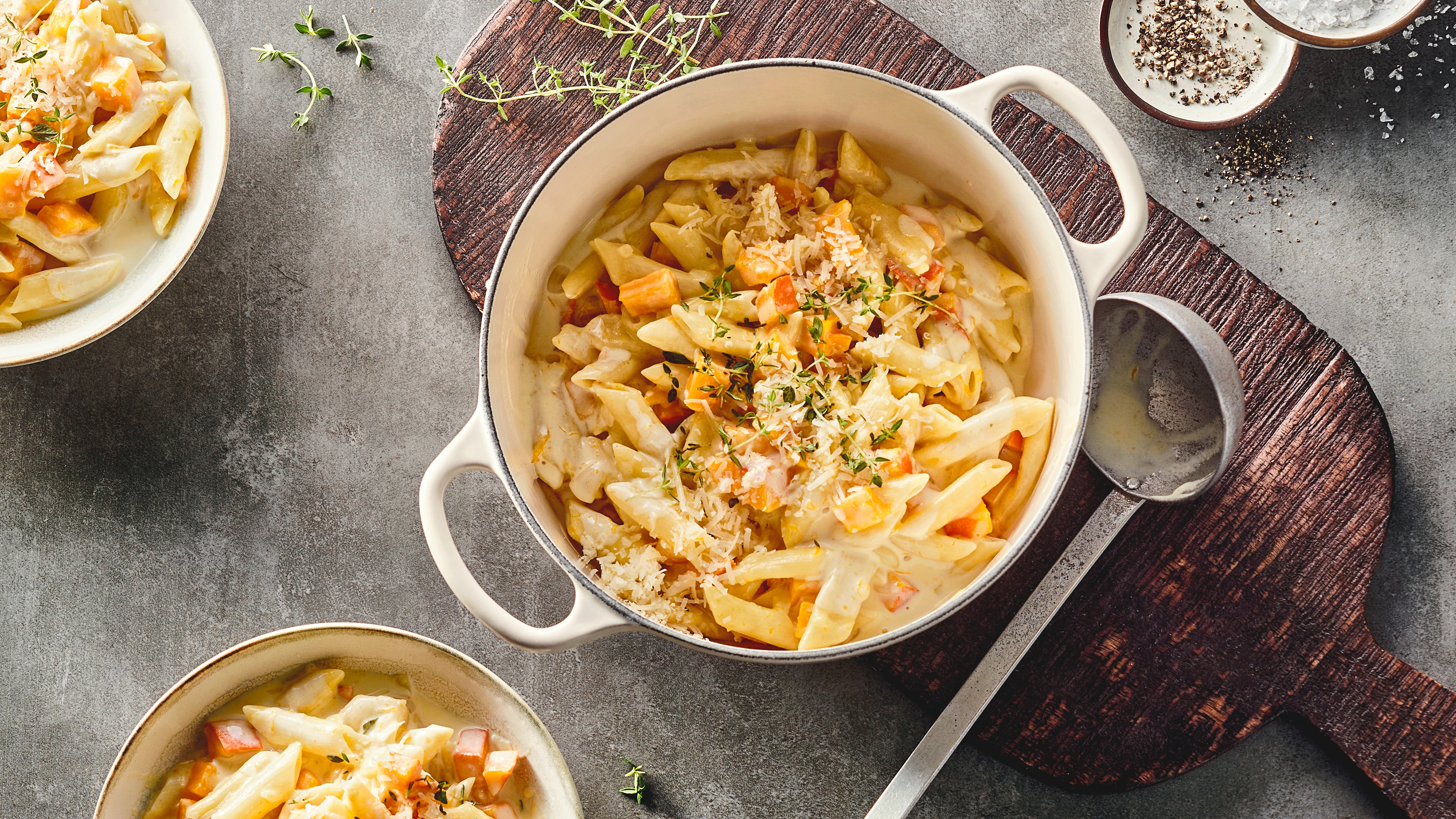 Rezept für One Pot Kürbis Pasta Ein Topf mit cremiger Penne in heller Soße mit Kürbisstückchen, getoppt mit geriebenem Käse