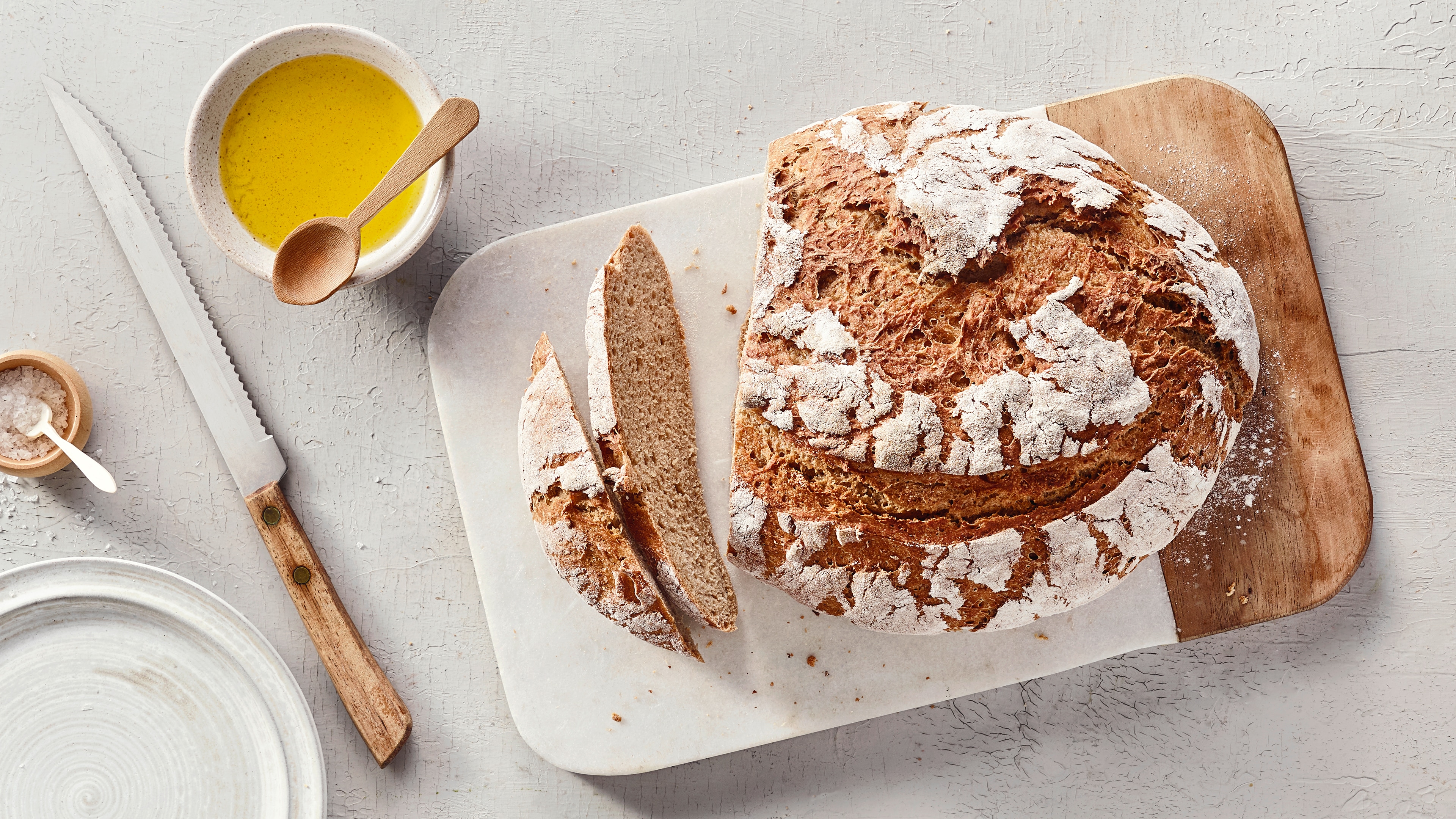 Ein Gitter mit Scheiben dunklem Kuchen und einem ganzen Stück, alle mit glatter brauner Glasur überzogen.