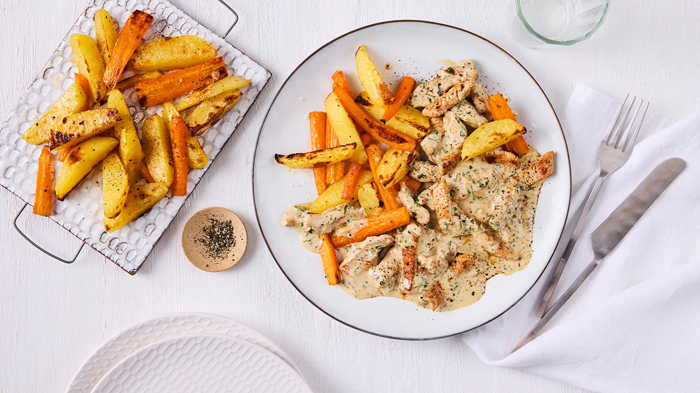 Knusprige Möhren- und Kartoffelspalten neben cremigem Ragout mit Fleischstücken