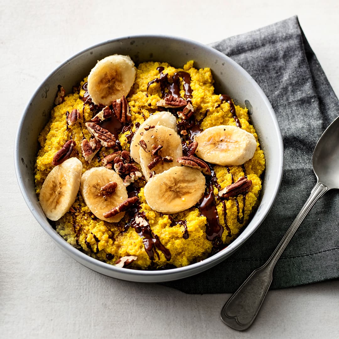Köstlicher Quinoa-Porridge verfeinert mit Vanille und Kurkuma. Das Ganze wird mit Mandelmilch angerührt und mit feiner Zartbitterschokolade verfeinert.