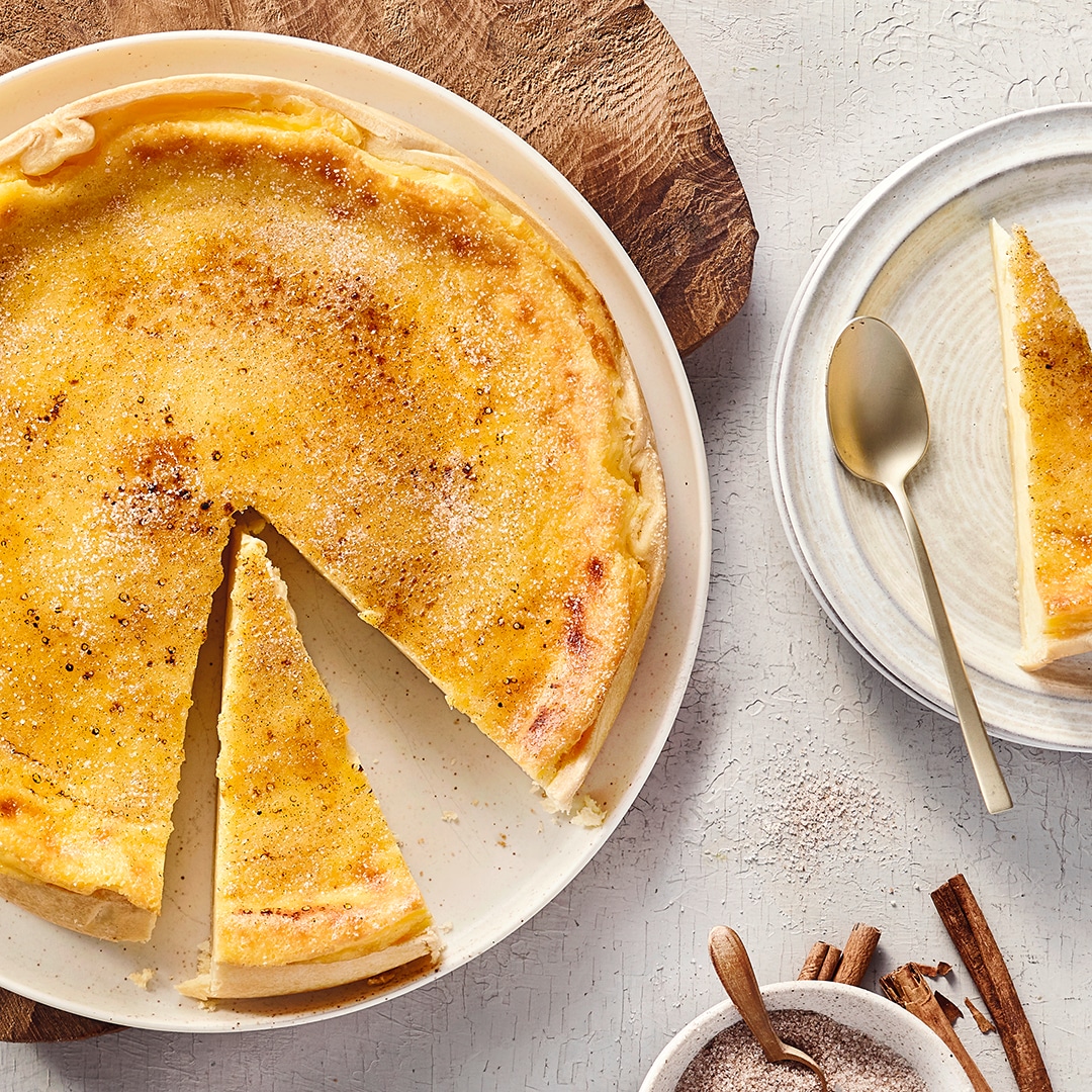 Runder rahmiger gelblicher Kuchen mit 2 ausgeschnittenen Stücken
