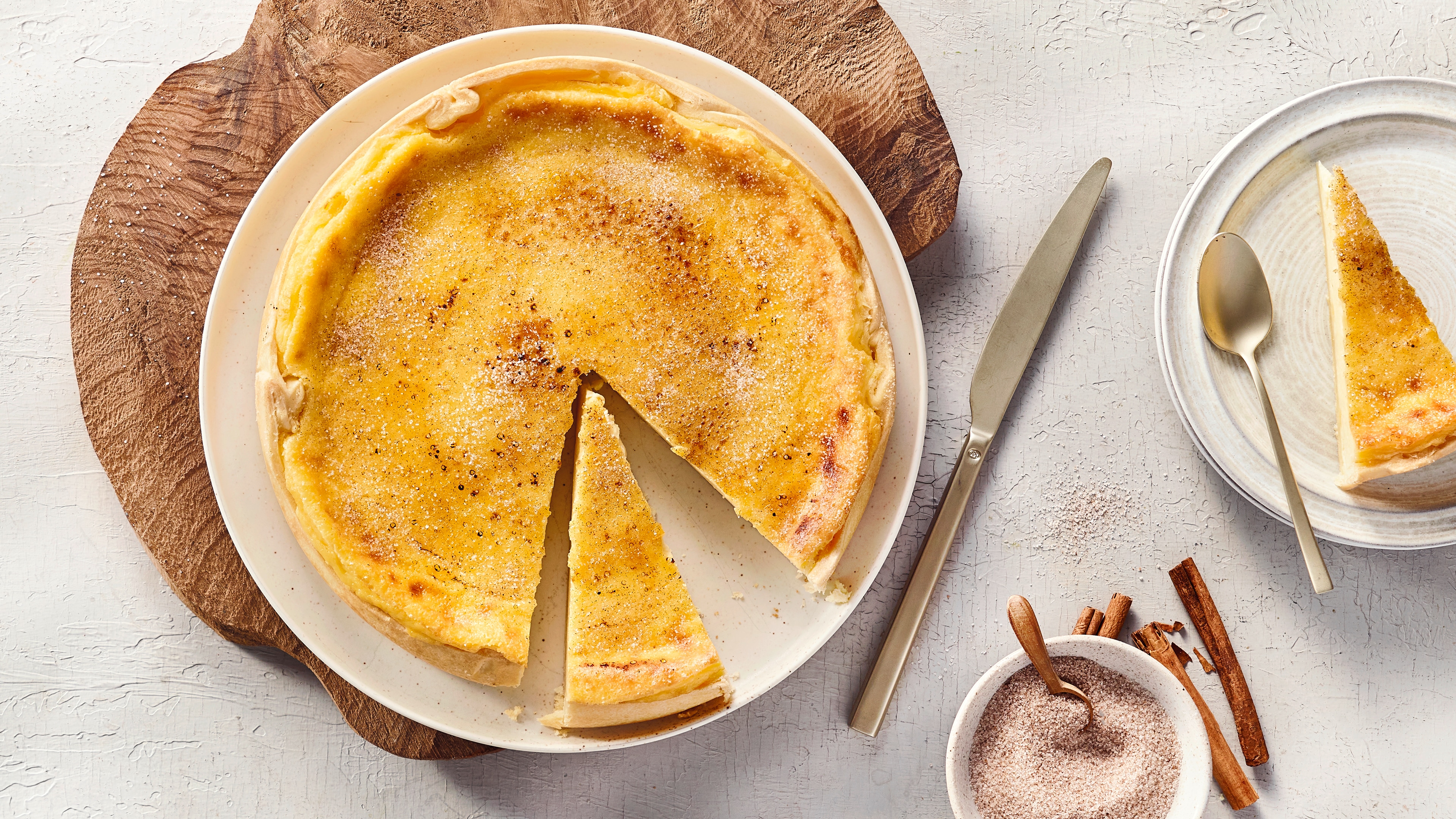 Runder rahmiger gelblicher Kuchen mit 2 ausgeschnittenen Stücken