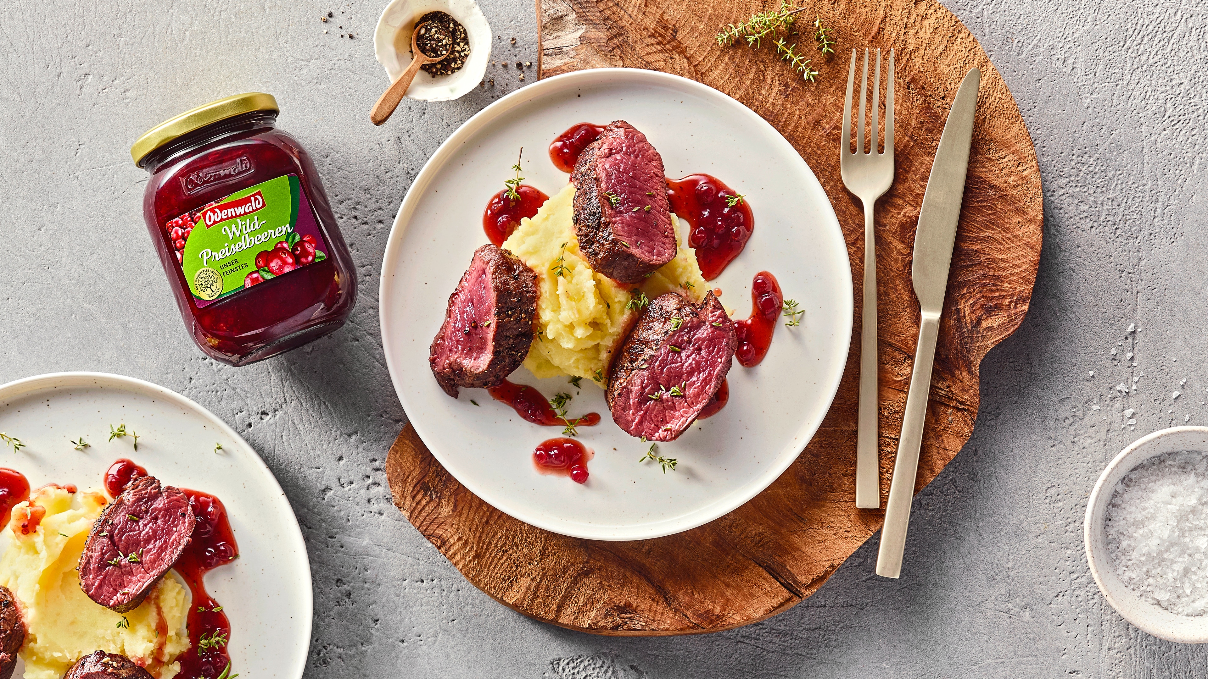 Teller mit Kartoffelpüree und Fleisch Medaillons mit Preiselbeersauce, daneben Odenwald Wild-Preiselbeeren