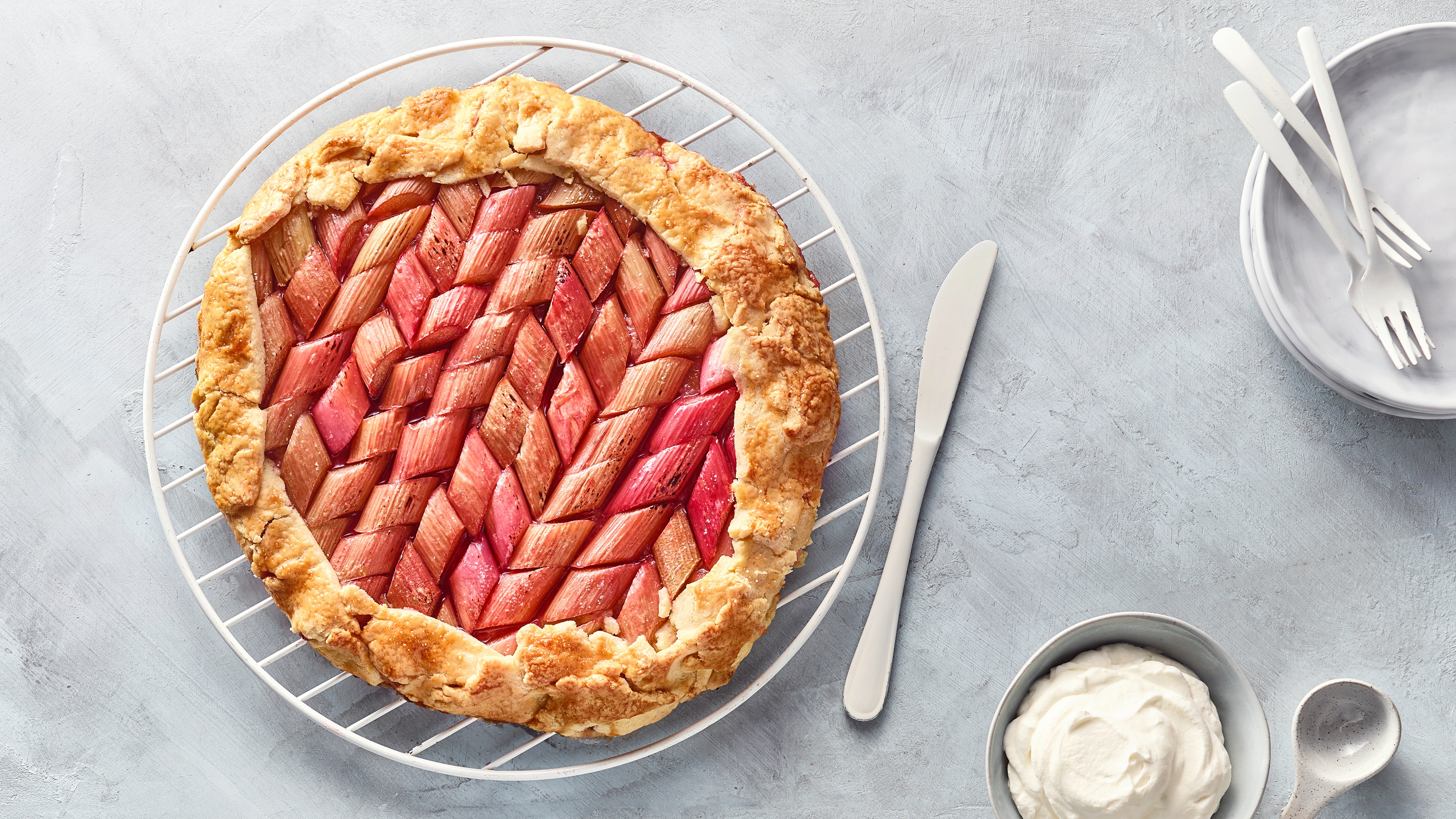 Rundes großes Gebäck auf Gitter mit Rhabarberstücken und Teigumrandung