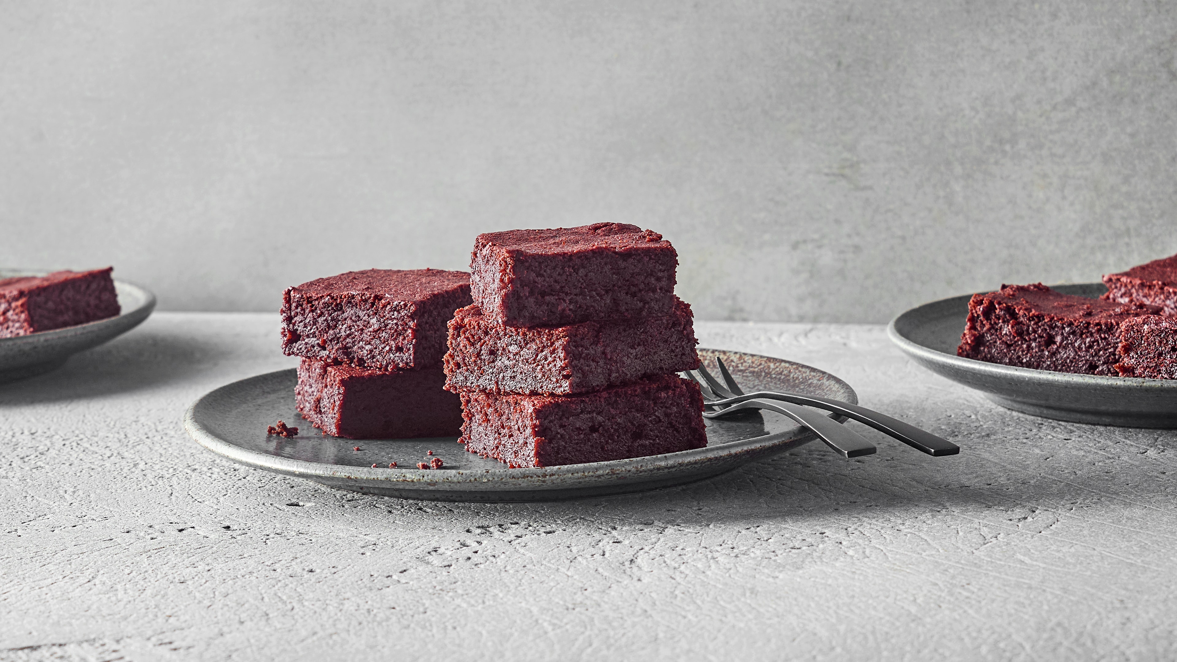 Ein Teller mit saftigen Brownies, daneben ein paar Krümel.